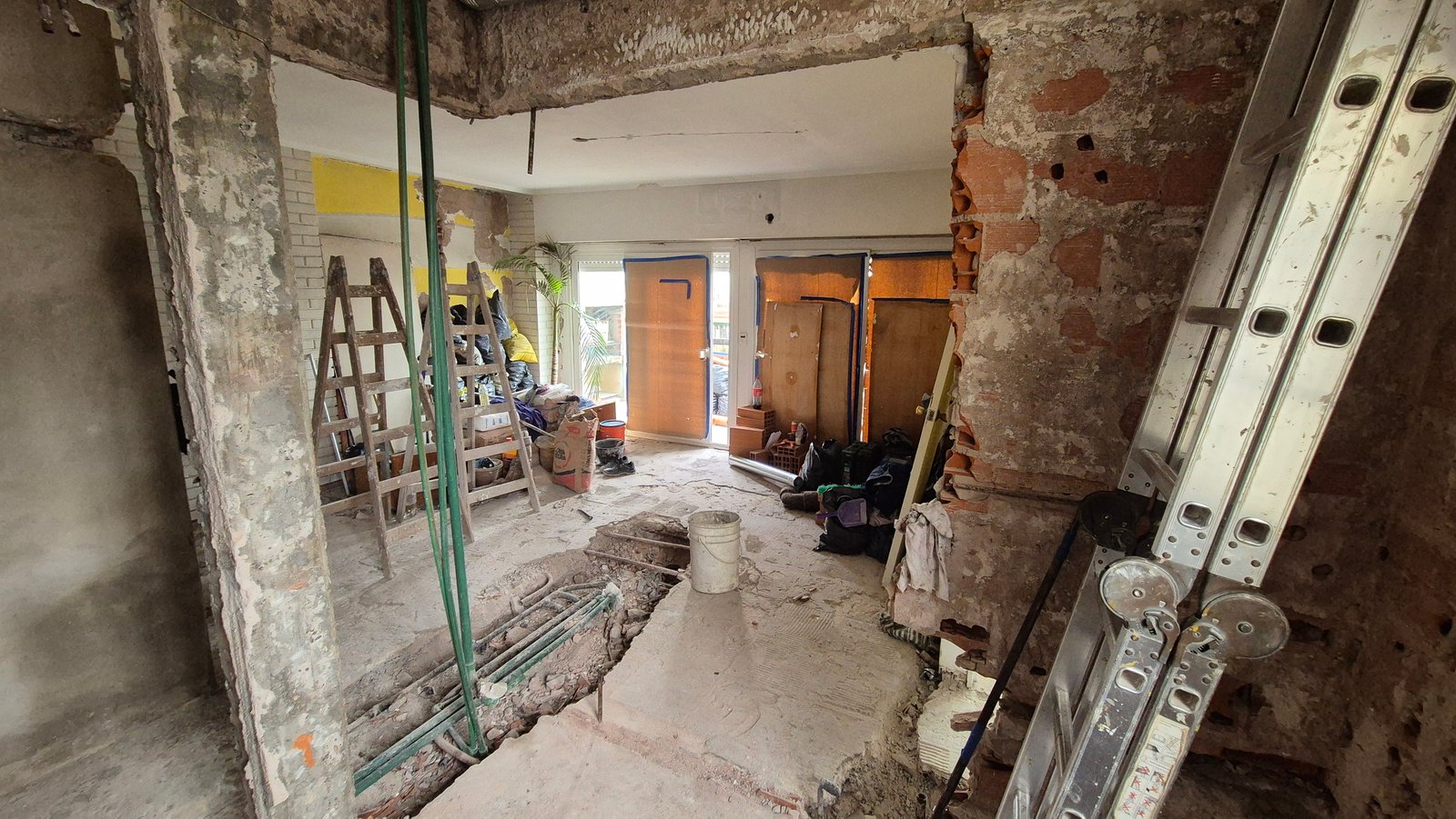 interior en construcción con paredes de ladrillo y hormigón expuesto — proyecto Cocina - Remodelación Soho, por RenovArqui, en Palermo