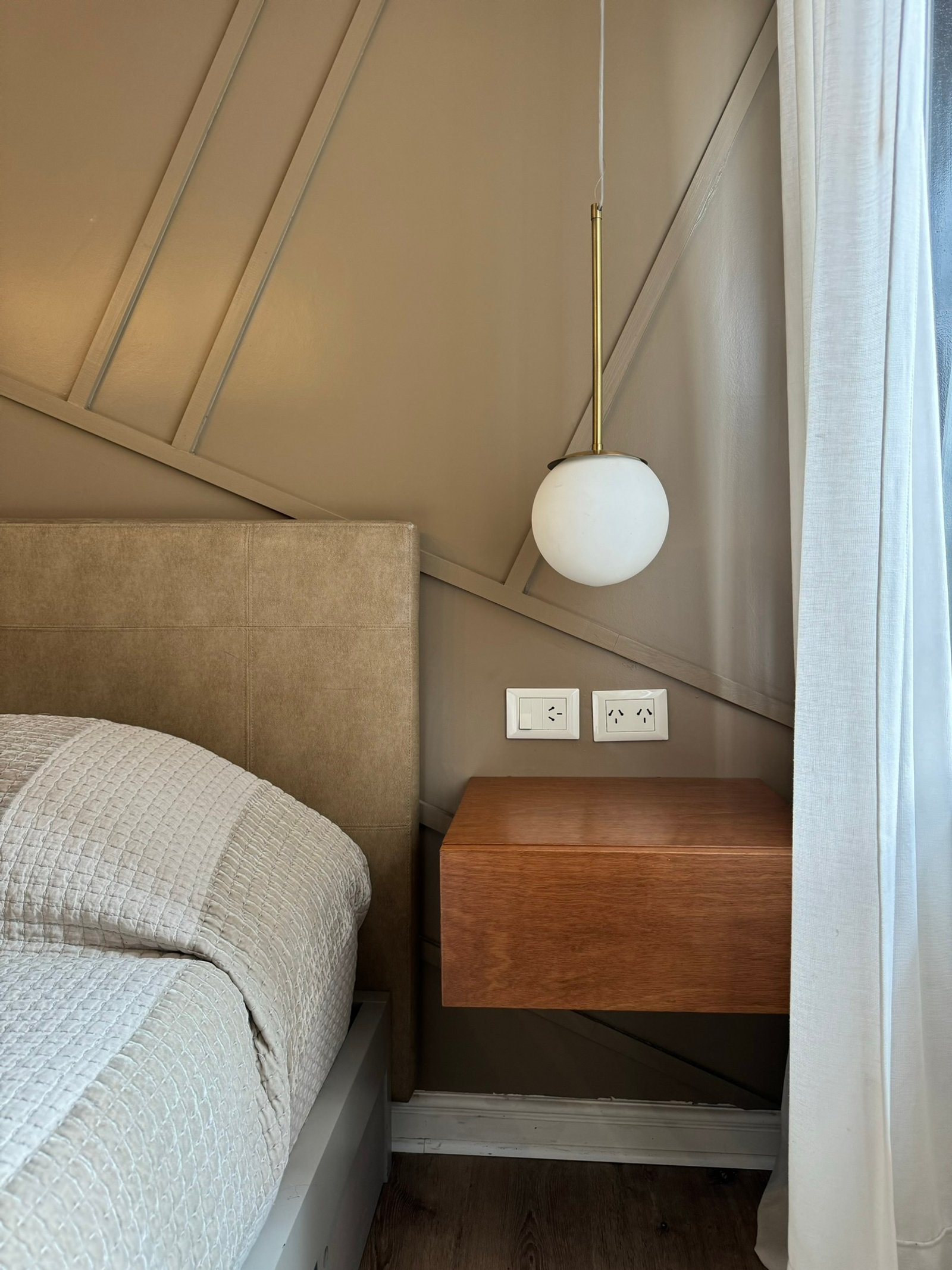 Quarto com painel de madeira e luminária pendente — projeto Coronel Diaz, por MDBK Arquitectura, em Palermo