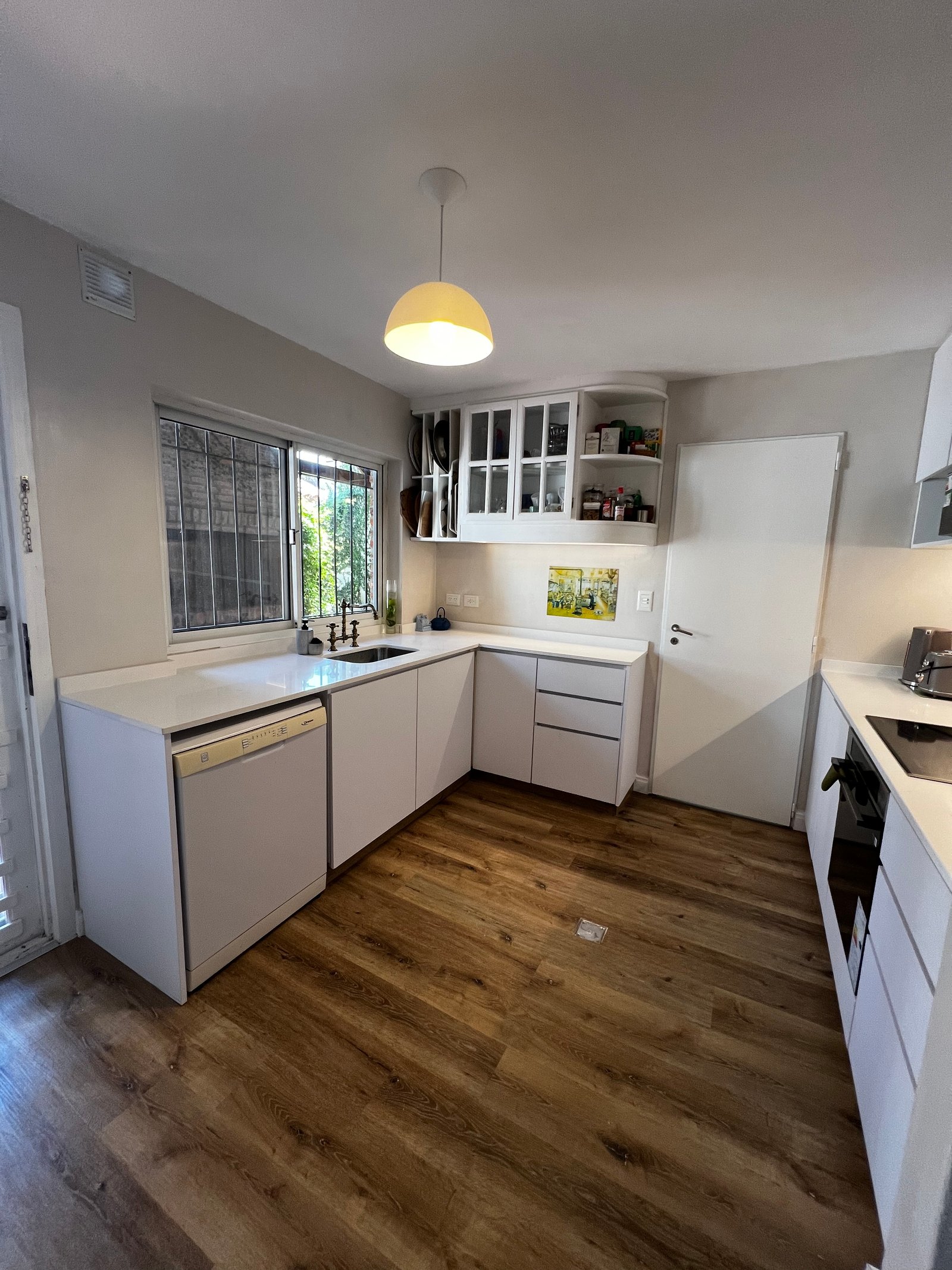 Cozinha moderna com piso de madeira e armários brancos — projeto Argentino Golf, por Estudio NET Arquitectura, em Golf Club Argentino
