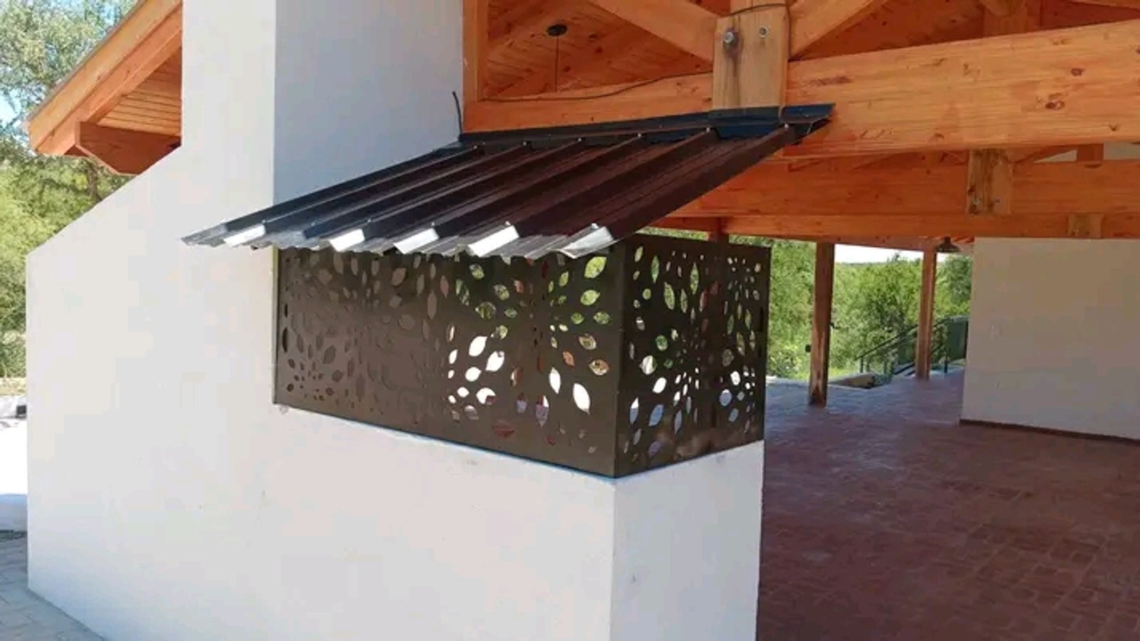  Fachada moderna con pantalla metálica calada y vigas de madera — proyecto Casa de Veraneo Bolcato, por HP arquitectura y obras/Raul Huerta Peña, en Nono