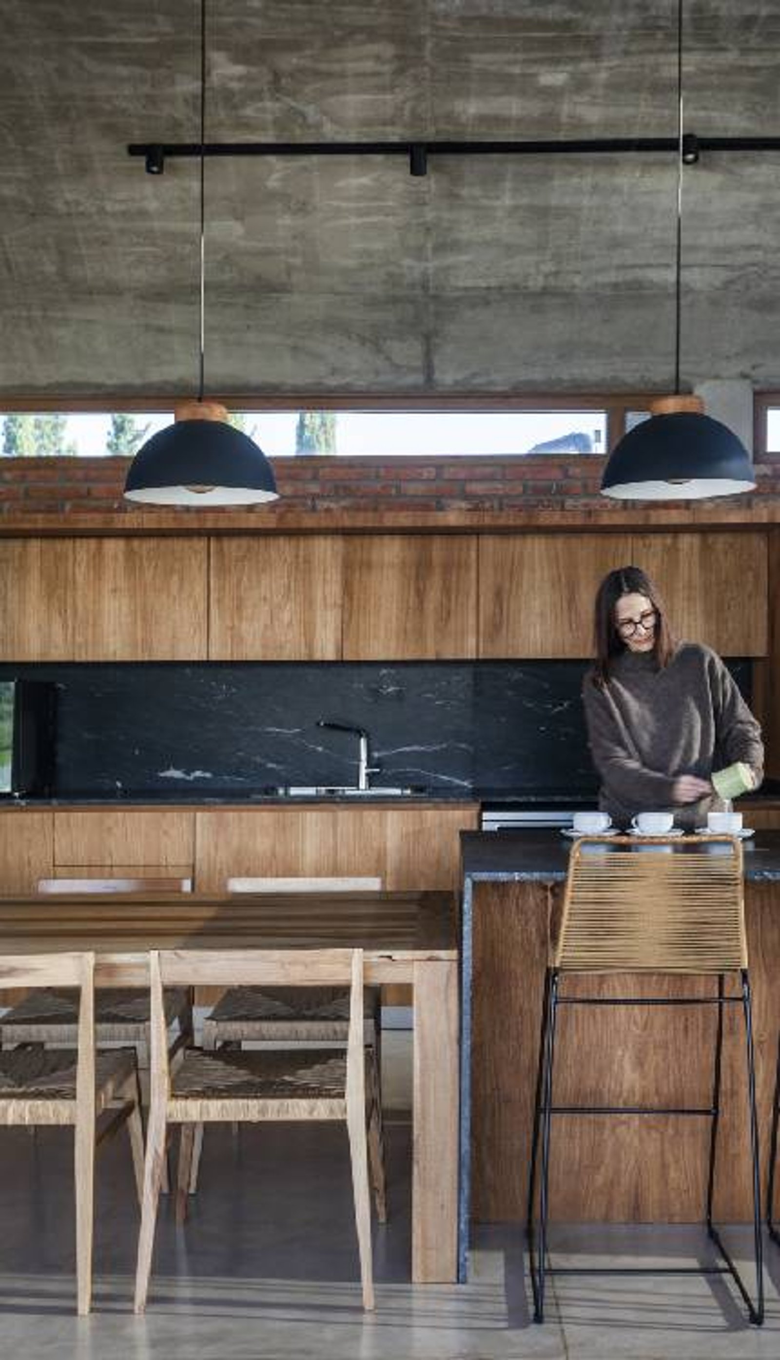 Cocina moderna con isla y detalles en madera natural y mármol — proyecto Casa Volt, por Estudio PK, en Capilla del Señor