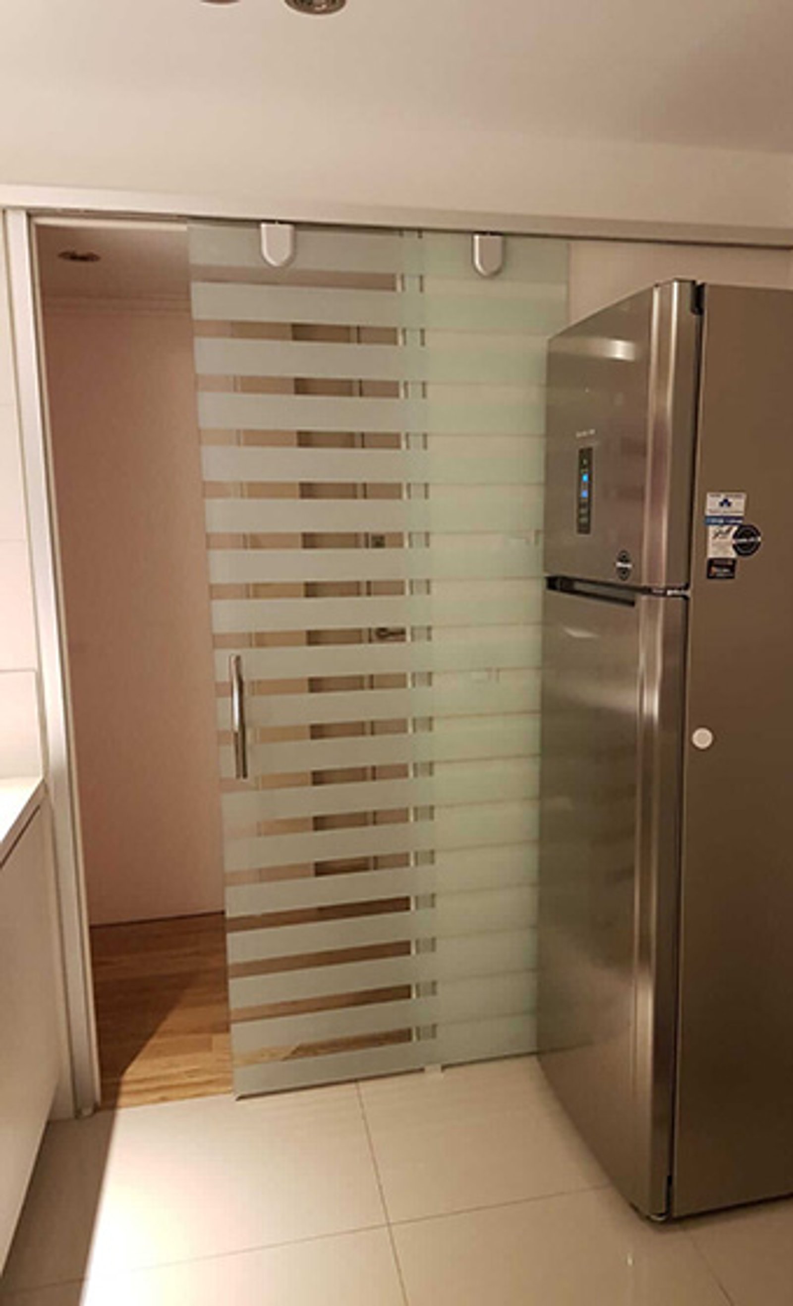 cozinha moderna com geladeira e porta de correr de vidro — projeto Puerta corrediza esmerilada plastificada, por Cristalcenter, em Villa Devoto
