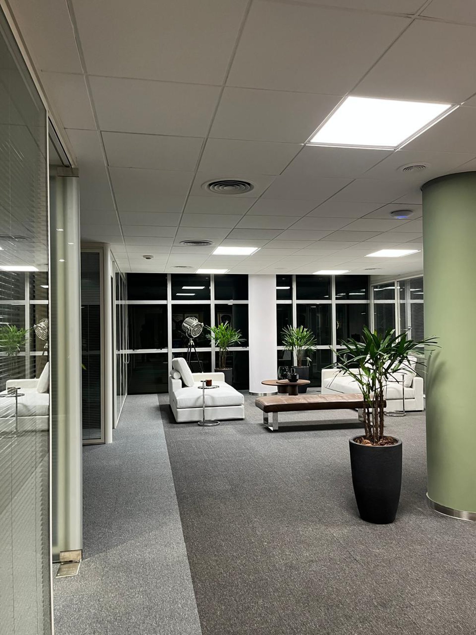 Sala de espera moderna de oficina con sofás blancos y plantas — proyecto Oficinas Cordoba, por Arcucci Arquitectura, en Av. Córdoba