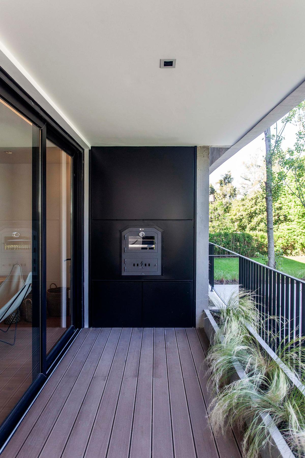 Terraço moderno com deck de madeira e churrasqueira embutida — projeto Alvear AV, por V2 Arquitectos, em City Bell