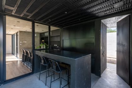Quincho moderno con isla negra y techo metálico, diseño industrial minimalista — proyecto Casa SI, por Grupo Studio, en Villa Allende