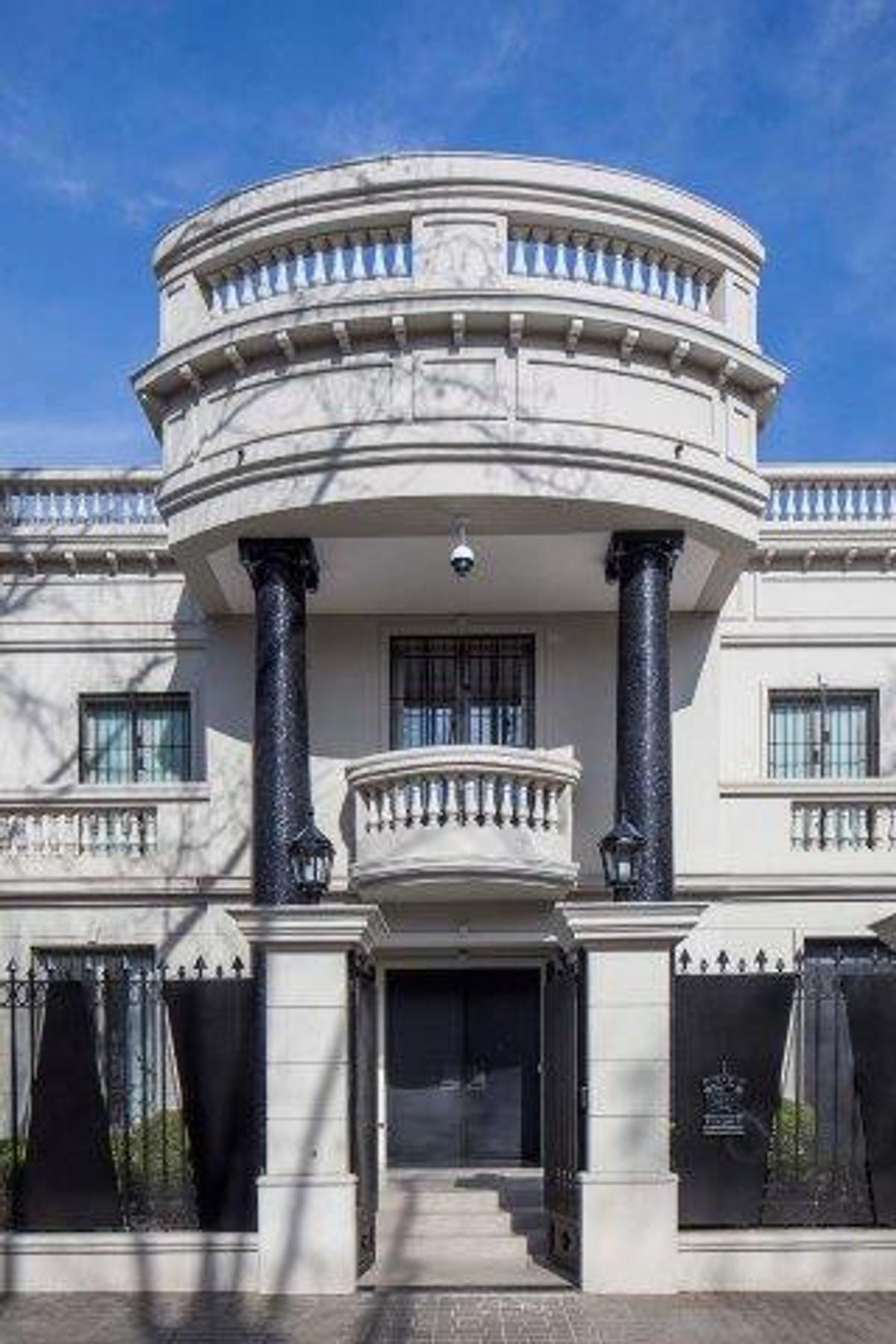 Fachada de mansão clássica com colunas pretas e varanda curva — projeto Casa PMorán, por Vanguarda Arquitectos, em CABA