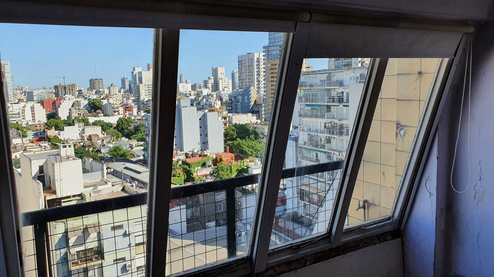 Vista urbana desde balcón de departamento moderno, con grandes ventanales — proyecto Aberturas DVH PVC - Reemplazo, por RenovArqui, en Palermo