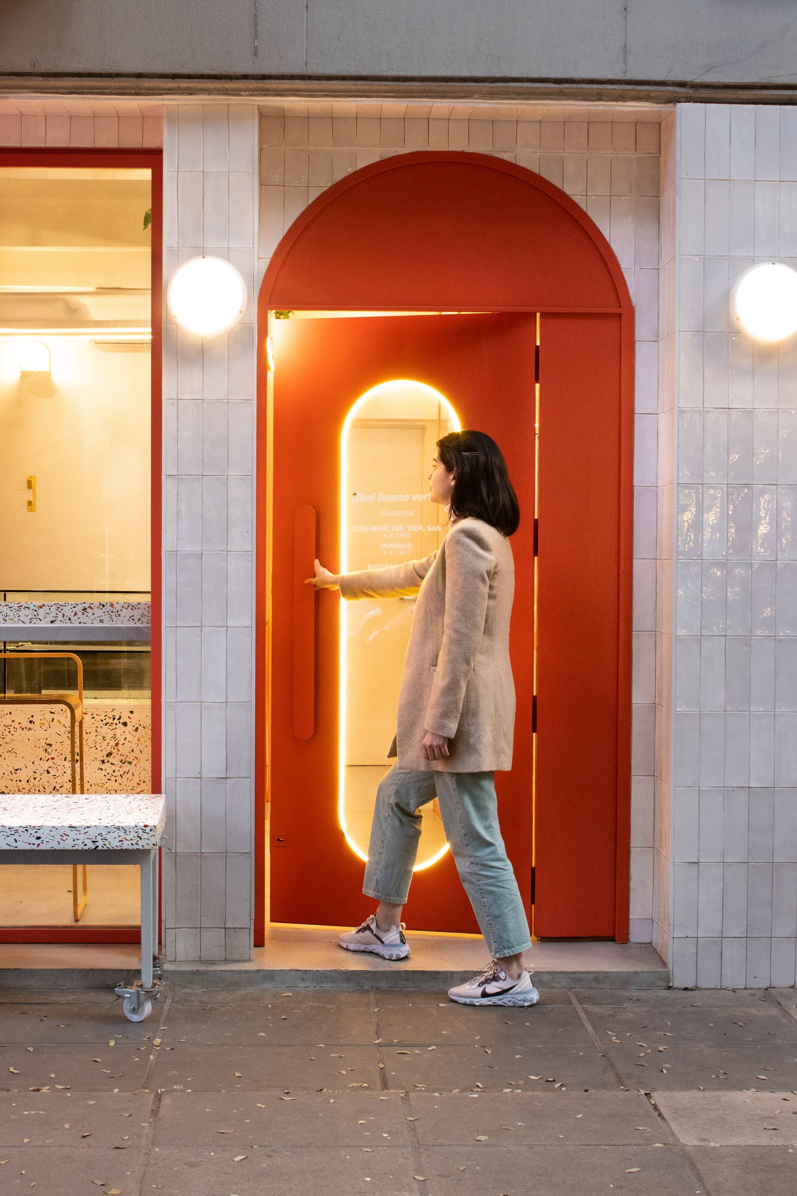 Fachada comercial moderna con puerta arqueada roja y luz de neón — proyecto Daniel bakery 1 , por KUPERDESIGN CONSTRUCCIONES SRL, en Av. Honduras 3714