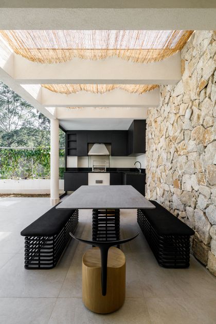 Quincho moderno con pared de piedra y pérgola tejida — proyecto CASA DANIELA ALPHA, por Yannick Athia, en São Paulo