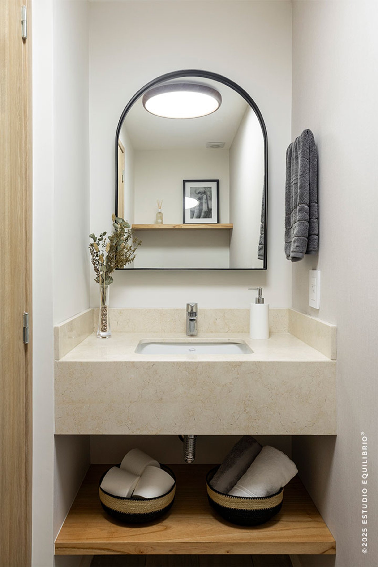 Baño moderno con espejo arqueado y mesada de mármol — proyecto Proyecto Nazca, por Estudio Equilibrio, en Villa Santa Rita