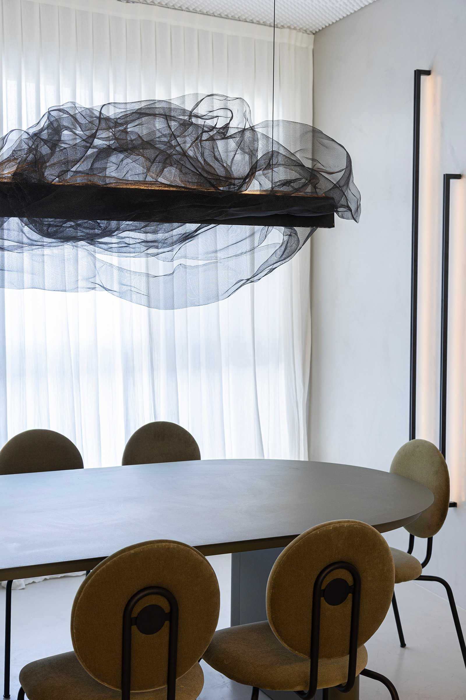 Sala de jantar moderna com mesa oval e cadeiras de tecido bege, lustre escultural — projeto HATSU Núñez - MZV Arquitectura, por Gaby Alfonso, em Buenos Aires
