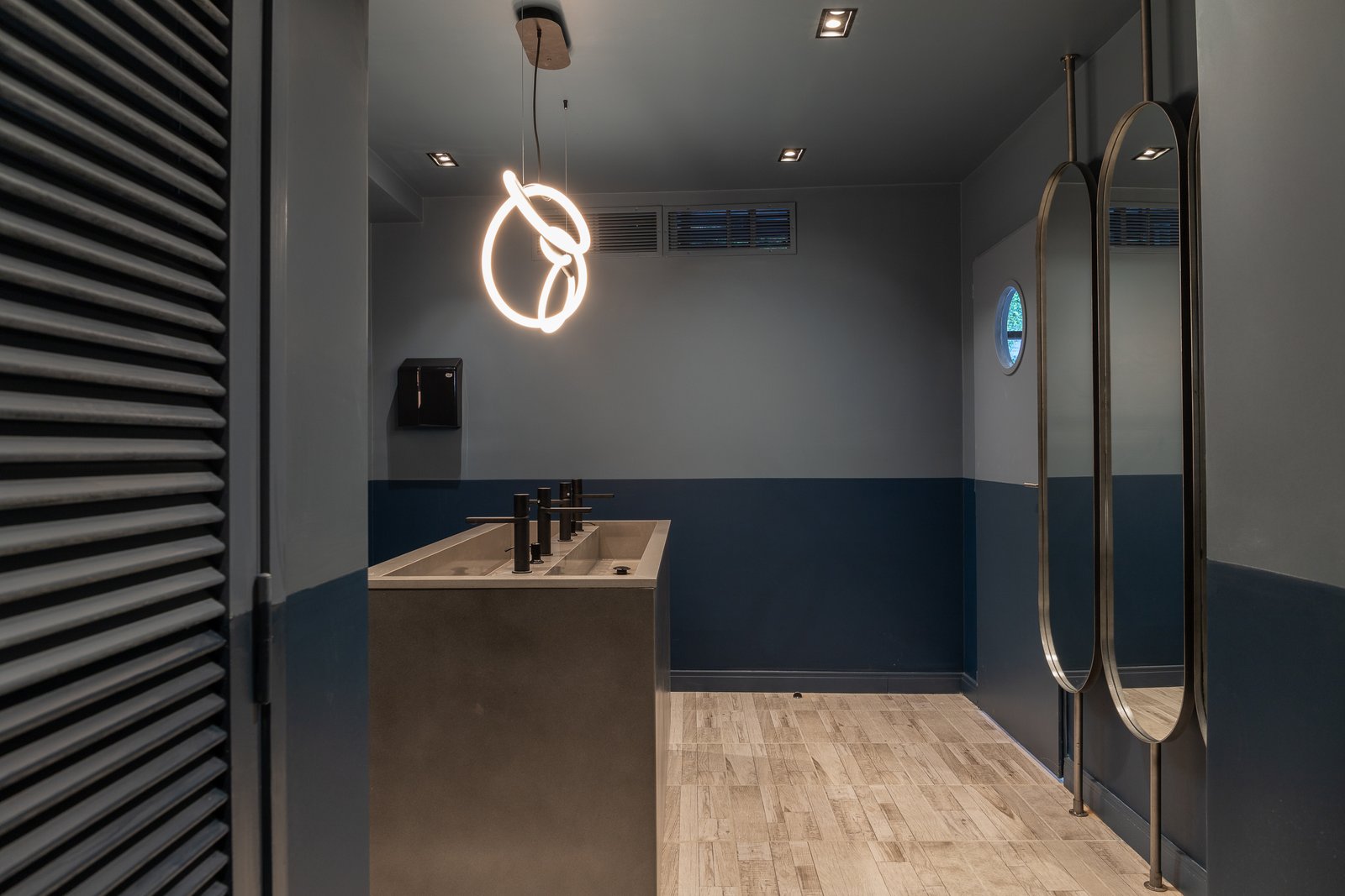 Banheiro moderno com luz neon circular e espelhos — projeto KALYS PIZZA, por AB ARQUITECTURA, em Núñez
