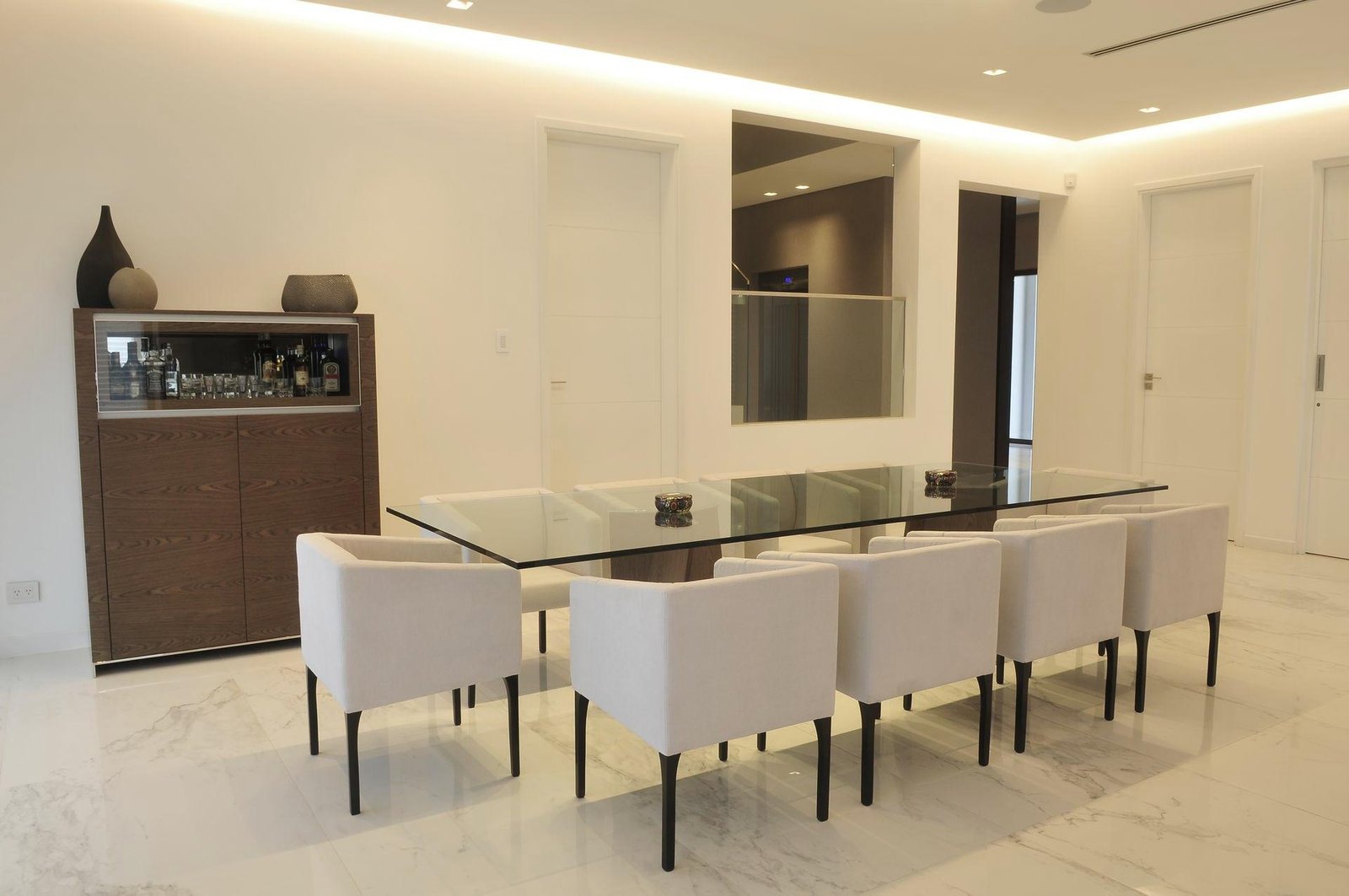 Comedor moderno con mesa de vidrio y sillas tapizadas — proyecto Espacios, por BURANI, en Martínez