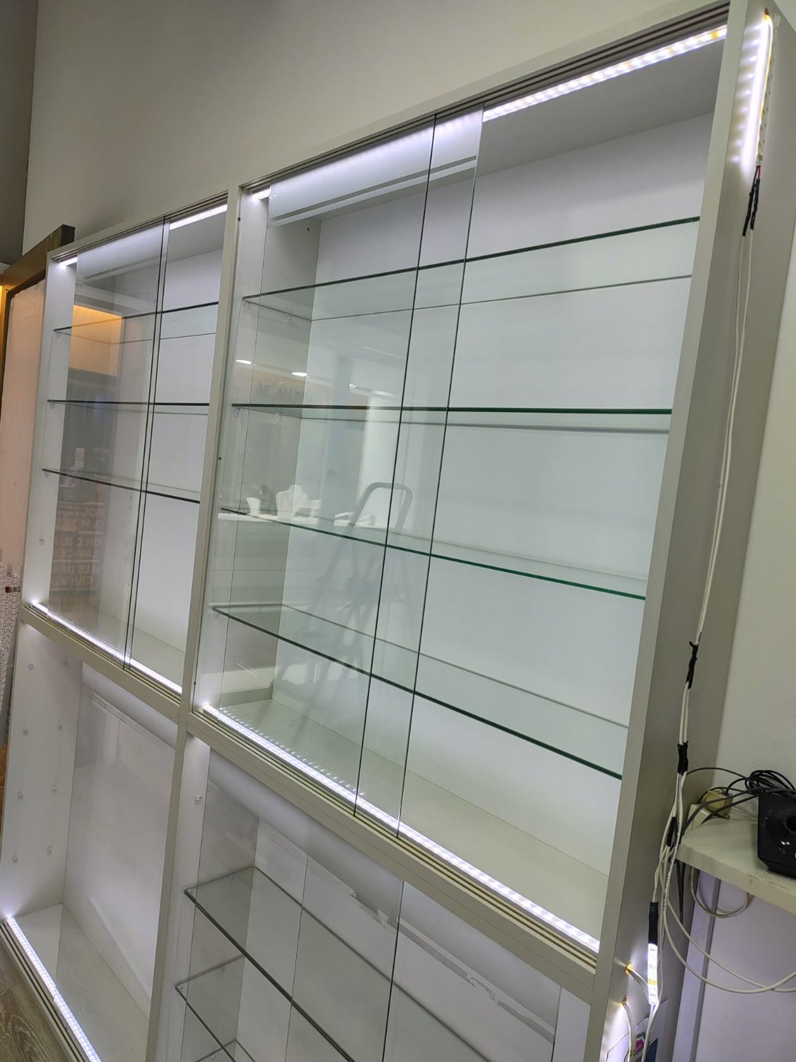 Prateleiras de vidro com iluminação LED em loja — projeto PORTOFINO JOYERIA, por Yamil Cerna, em Av. San Martín 1027
