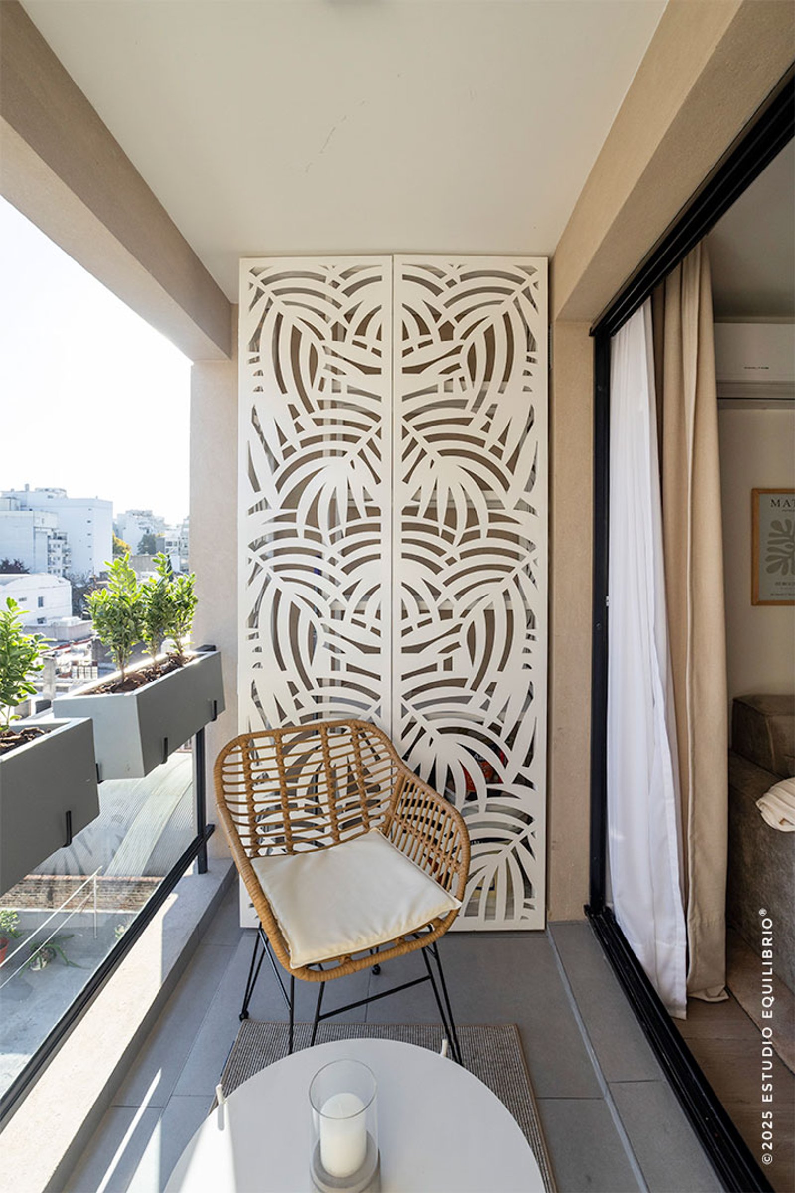 Balcón moderno con biombo calado y sillón de mimbre — proyecto Proyecto Nazca, por Estudio Equilibrio, en Villa Santa Rita