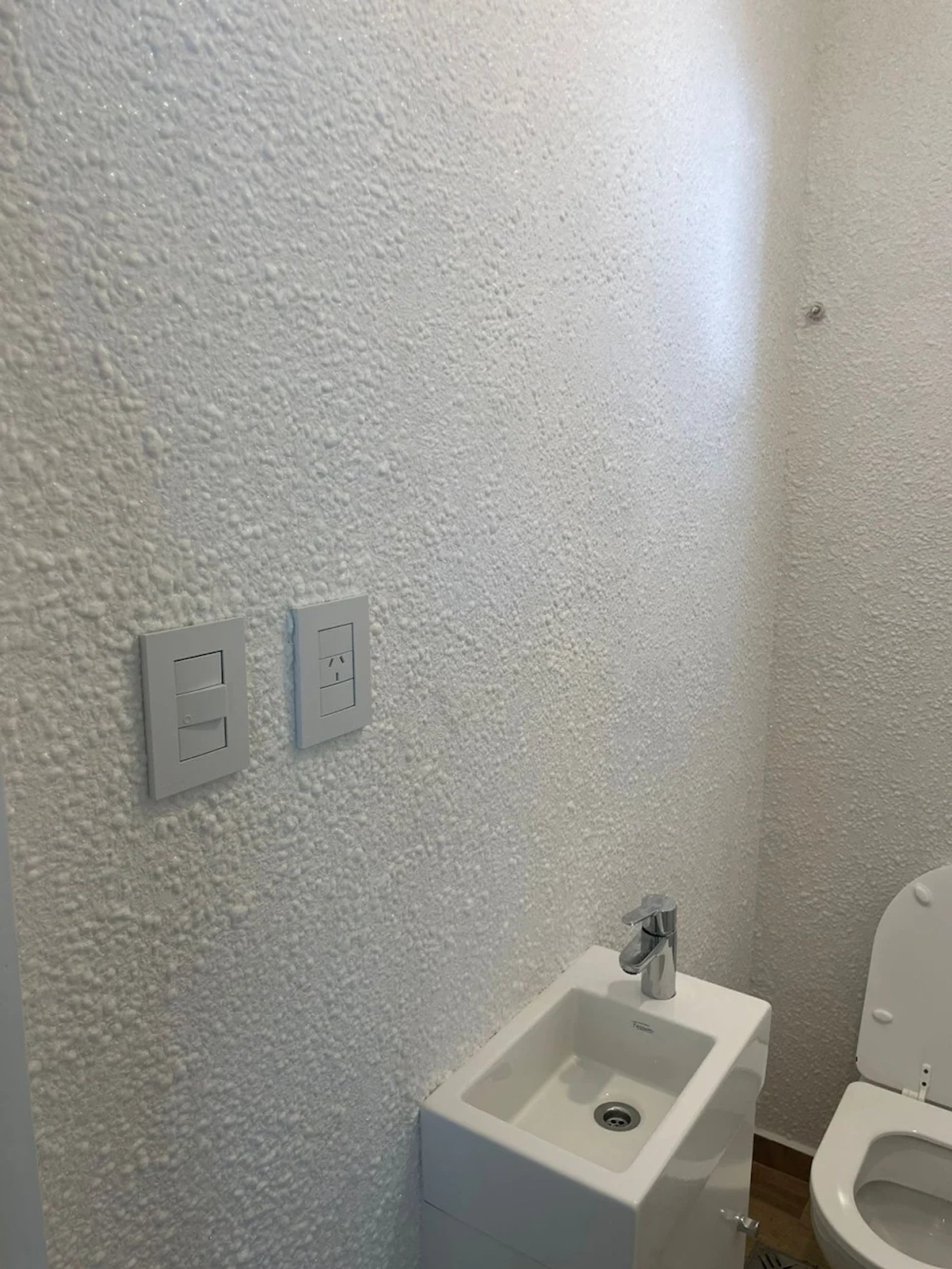 Baño compacto con lavabo blanco y grifería cromada — proyecto Baño, por ecodecor argentina, en Buenos Aires