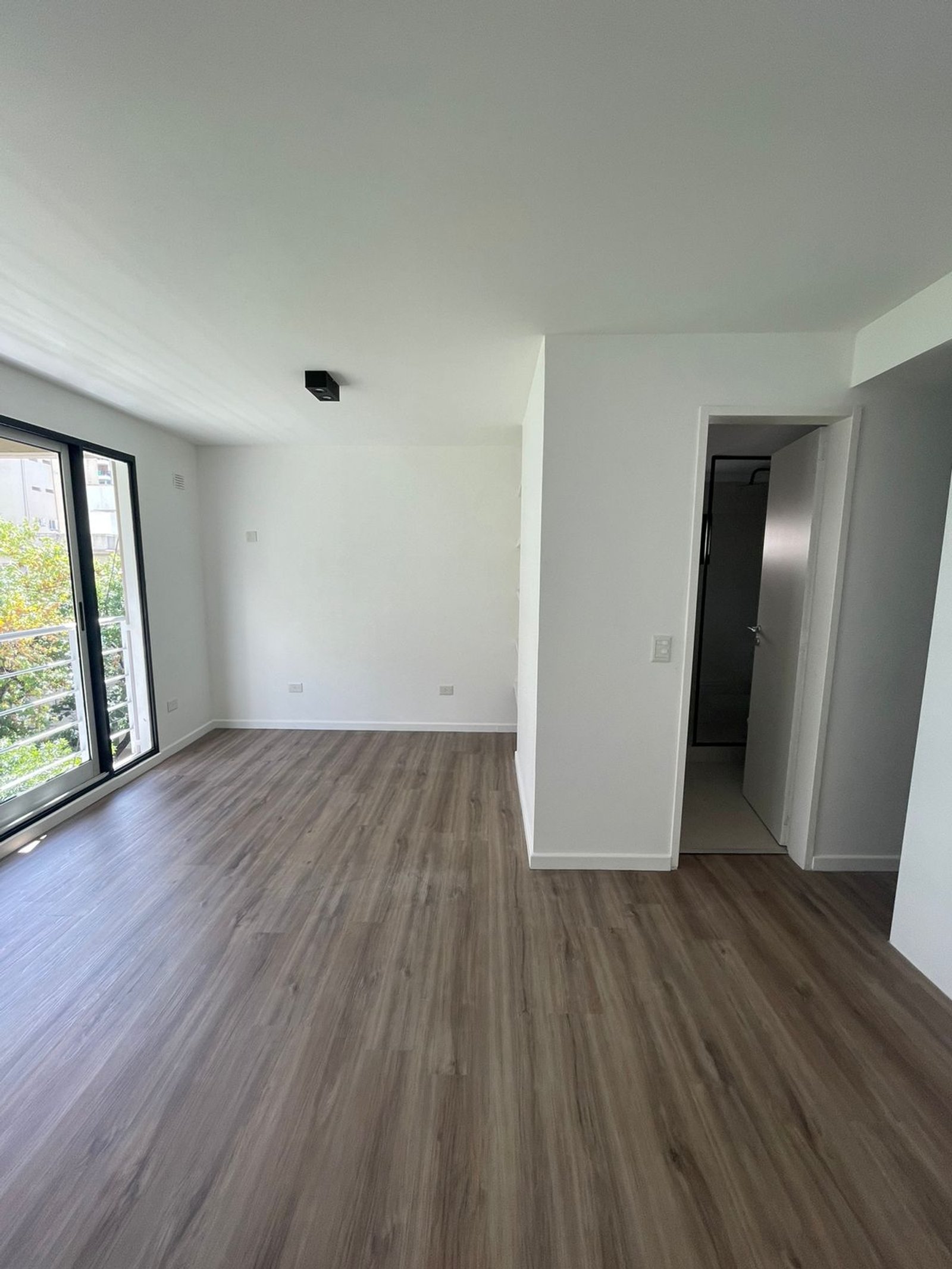 Living moderno con pisos de madera gris y mucha luz — proyecto Jorge Newbery , por Estudio NET Arquitectura , en Av. Jorge Newbery 1820