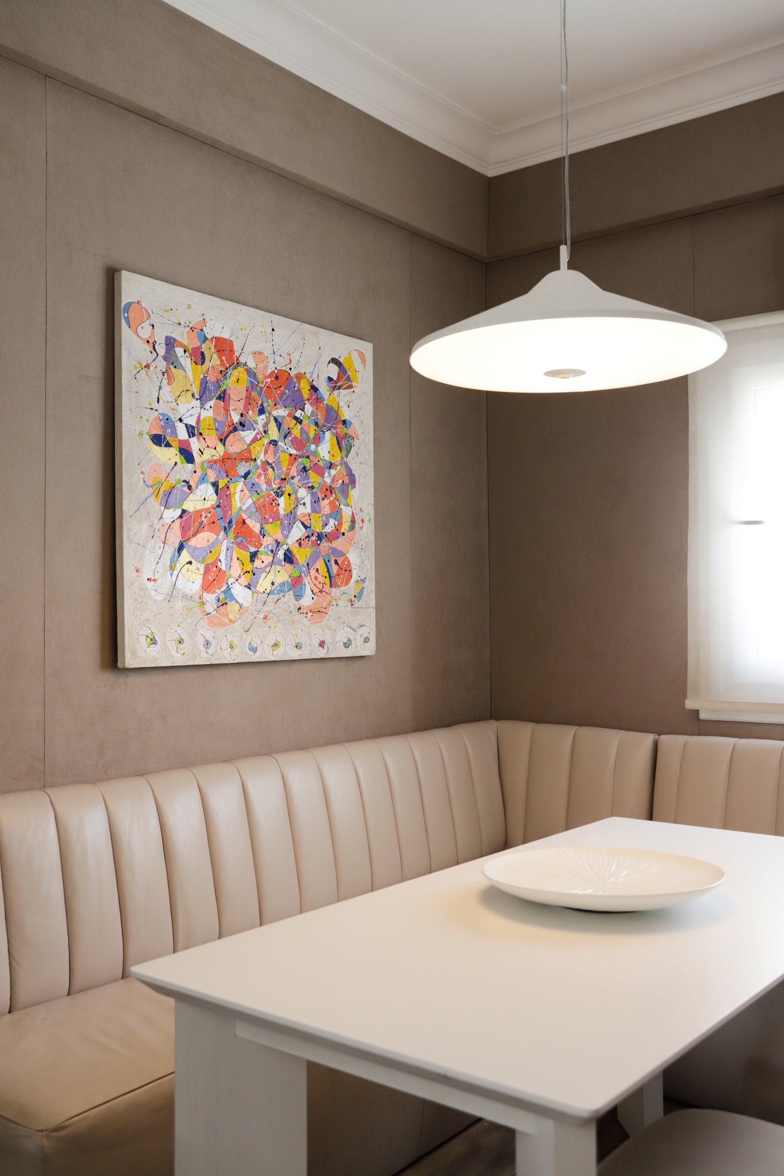 Comedor moderno con sillón de cuero, obra de arte y lámpara colgante — proyecto OBRA GUEMES, PALERMO, por MARCELO MAZZA, en Palermo