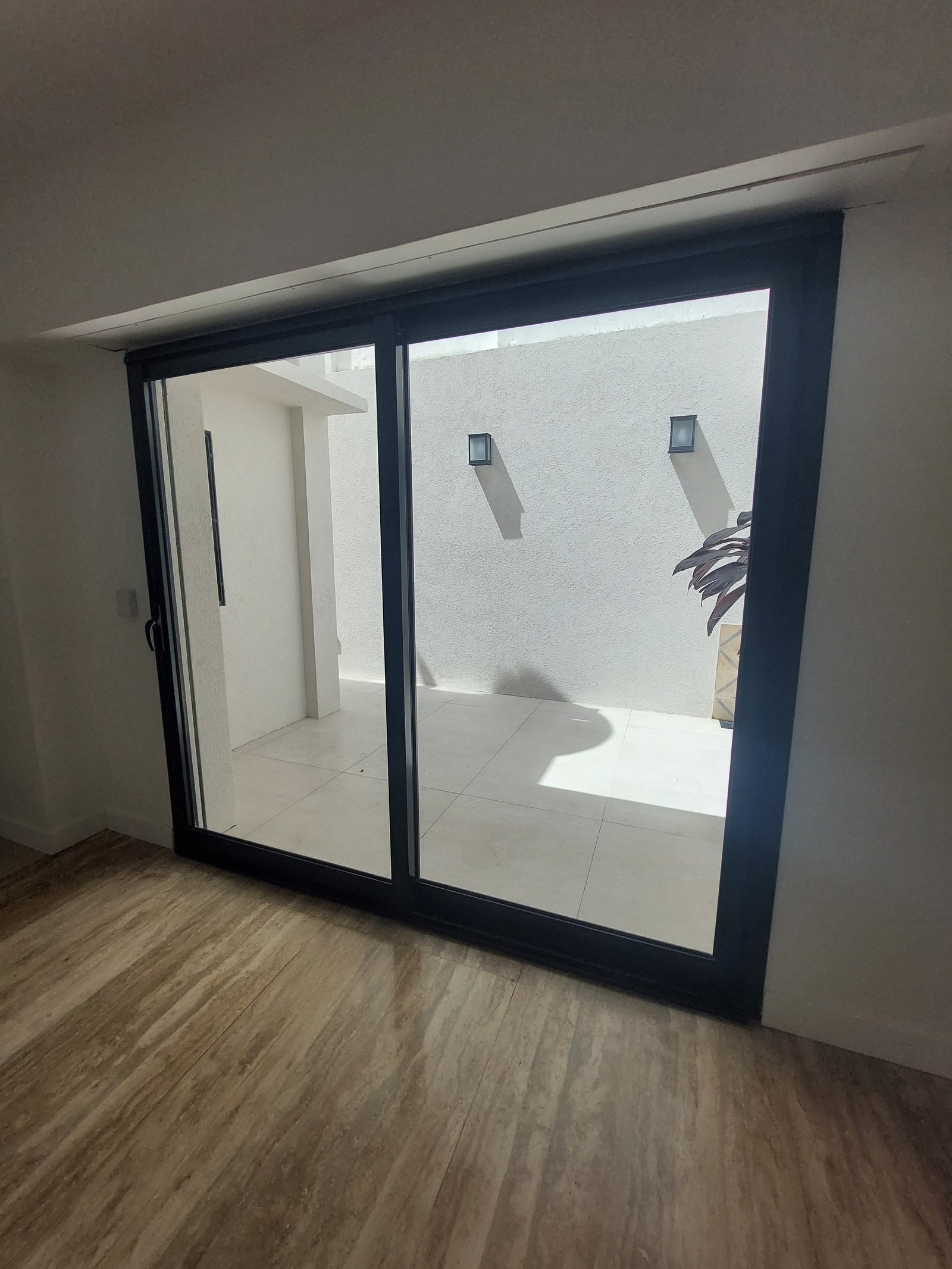 Pátio moderno com janelas amplas e piso de madeira — projeto MISTRAL, por Arquitecta, em Villa Pueyrredón