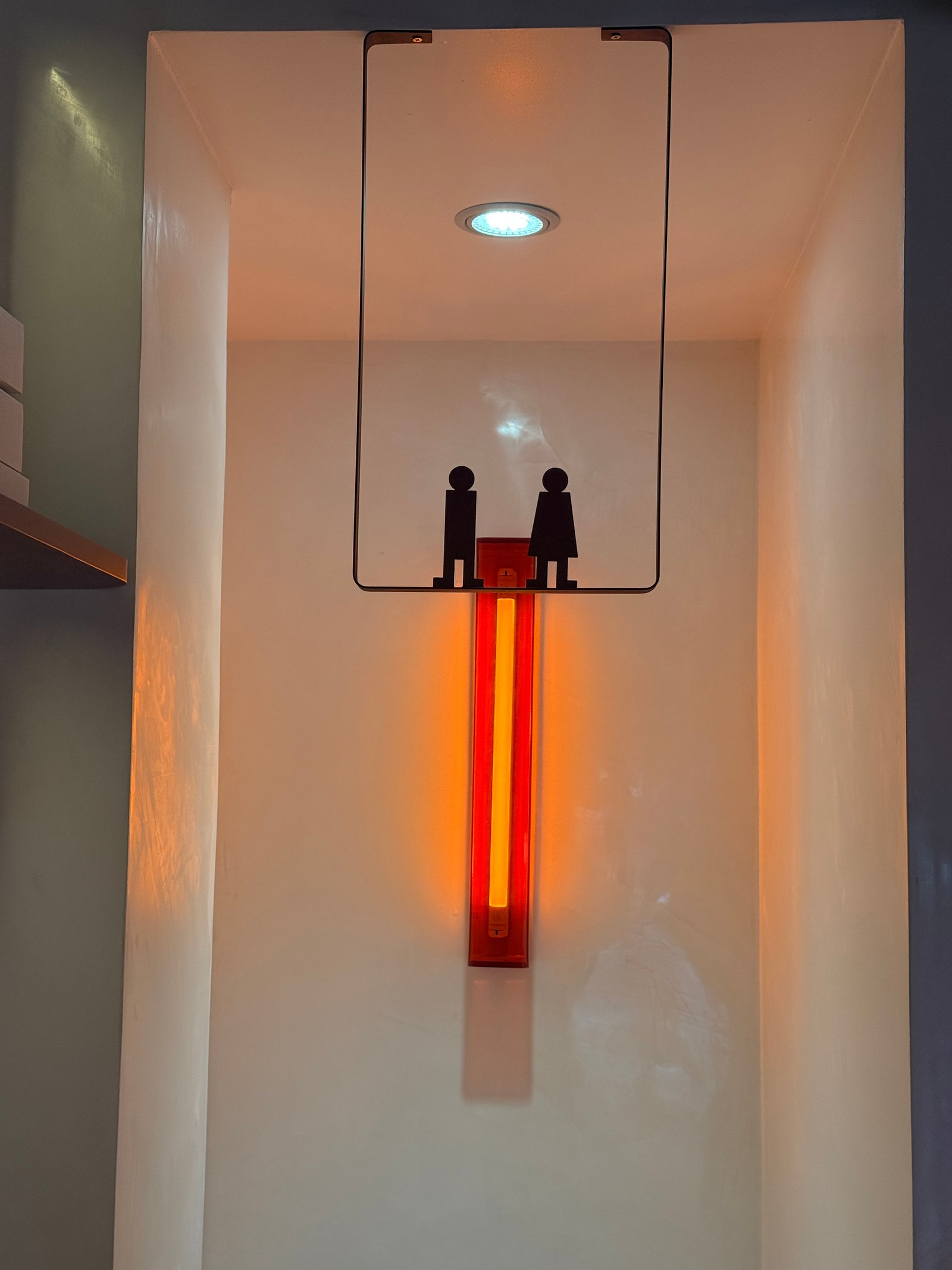 Luz de neón vertical y figuras silueta en nicho empotrado — proyecto Lunático, por Estudio Losa, en Av. Corrientes 1659
