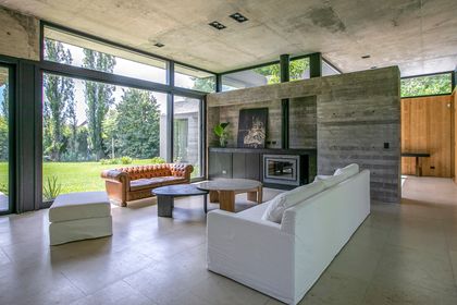 Sala de estar moderna de hormigón con vista al campo — proyecto CASA MG, por IMF INÉS MARTINEZ FERRARIO