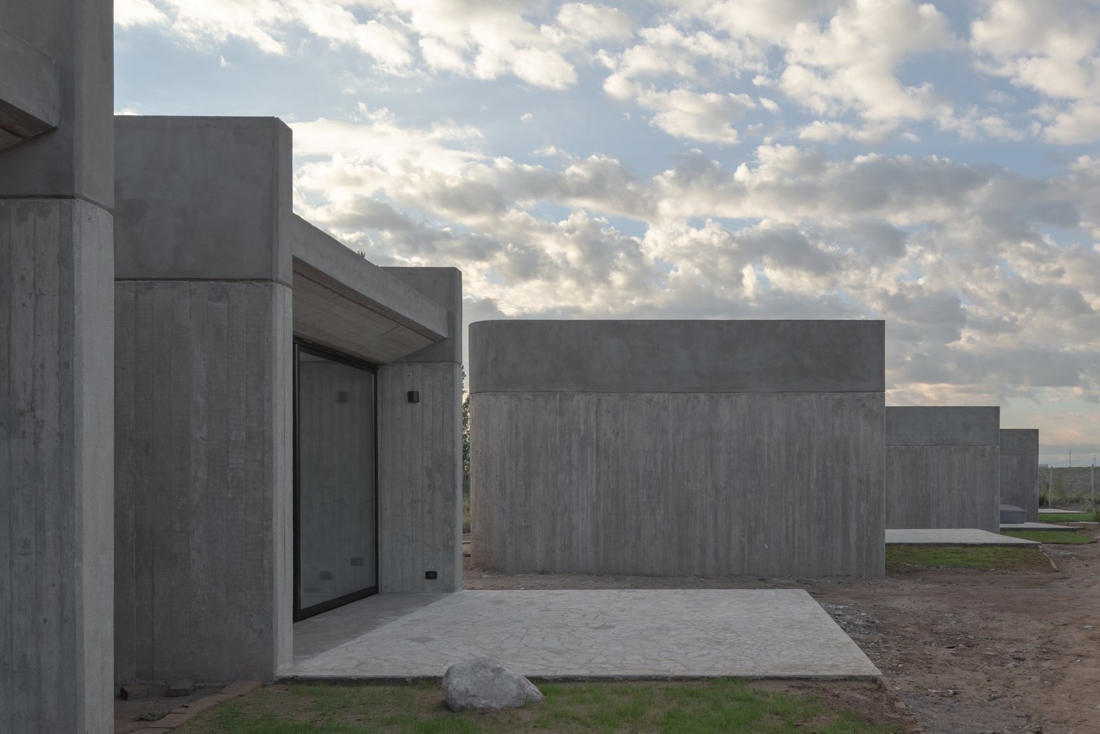 Edificios modernos de hormigón visto en entorno rural — proyecto Complejo SCV, por ONA - Oficina Nómada de Arquitectura, en Las Compuertas