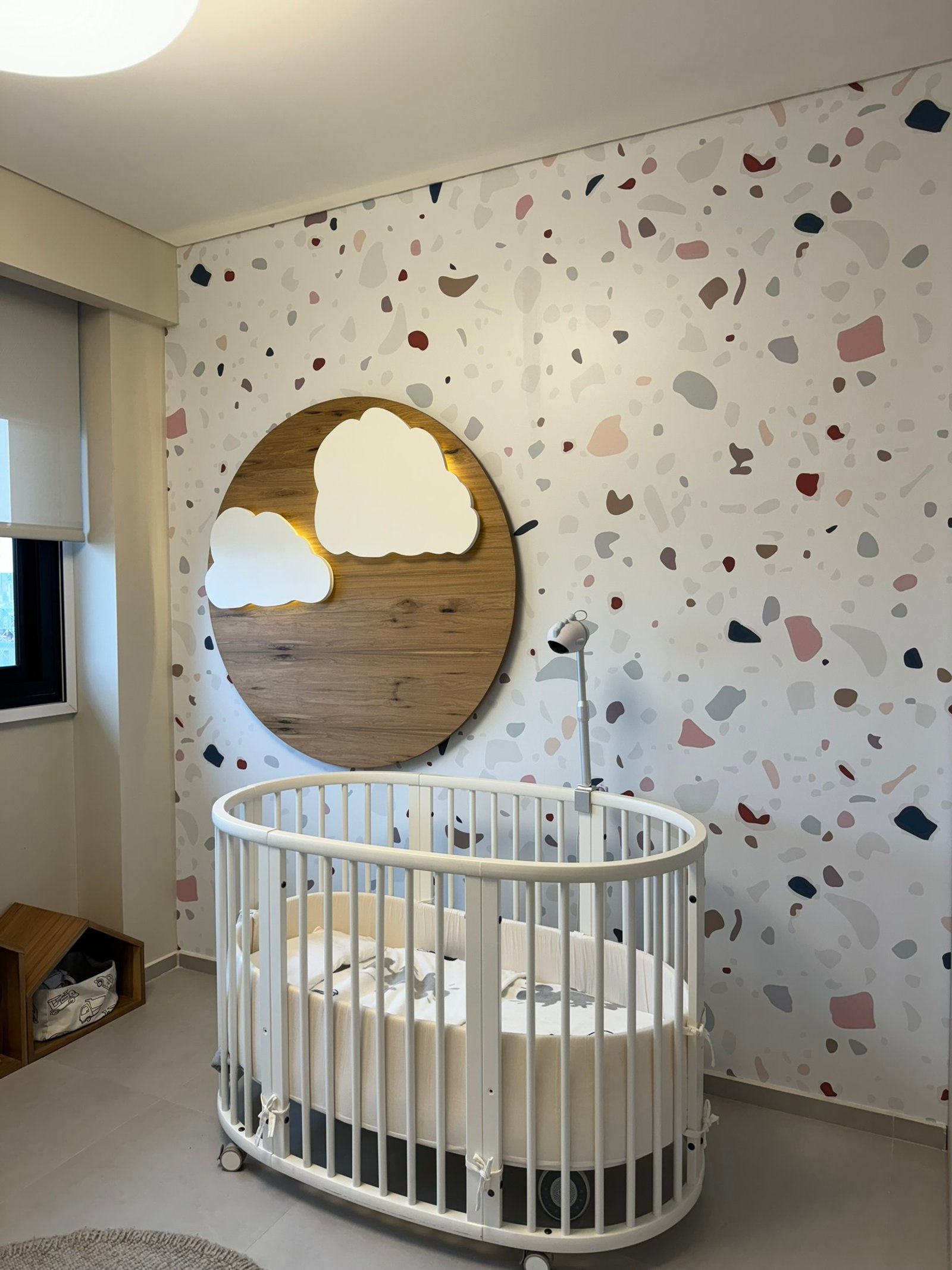 Quarto de bebê com berço oval e papel de parede de terrazzo — projeto Boyacá, por MDBK Arquitectura, em Caballito