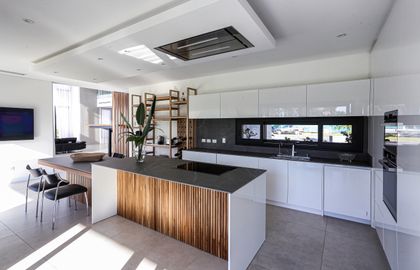 Cocina moderna de planta abierta con isla central y pared de listones — proyecto TRV 749, por Estudio Arq Daniel Tarrio