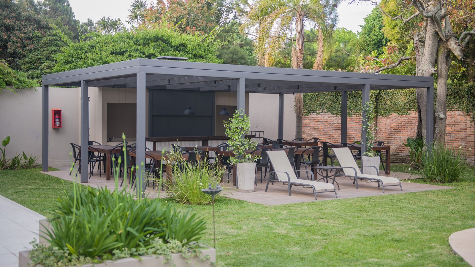 Patio moderno cubierto con pérgola y mobiliario exterior — proyecto Villa Isidro Hotel Boutique & Spa, por Hermann Arquitectos, en San Isidro
