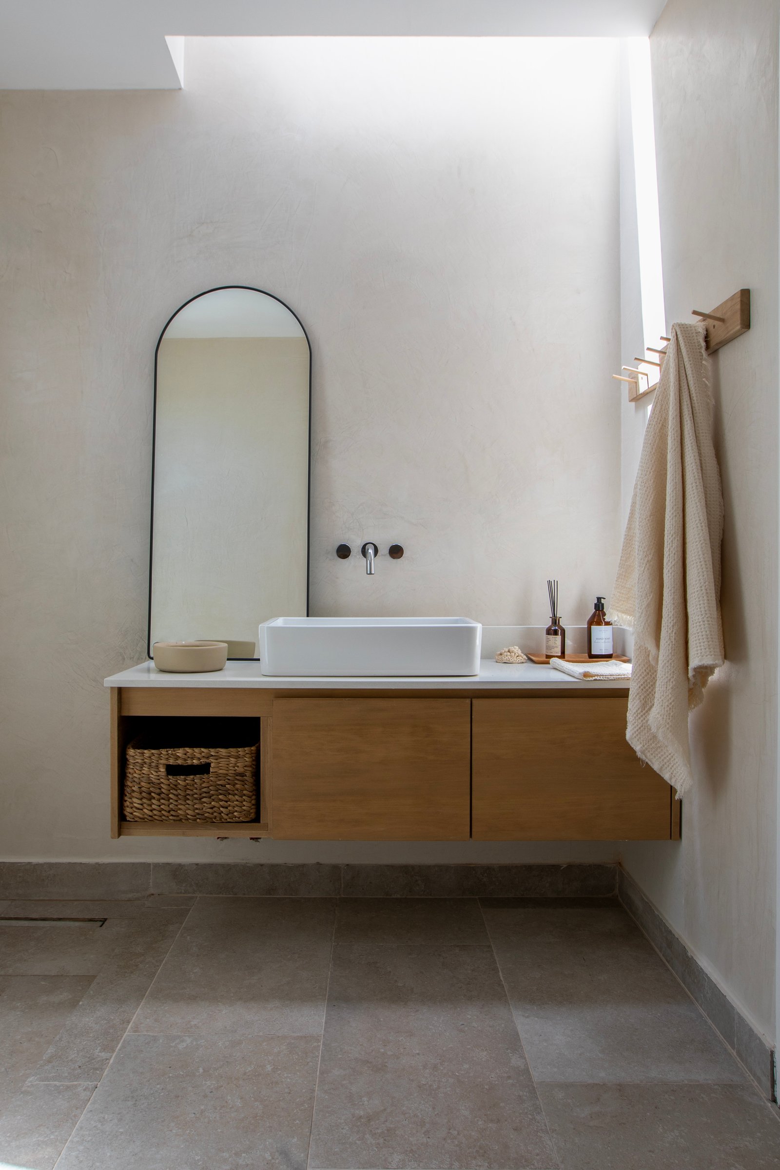 Baño moderno escandinavo con espejo arqueado y vanitory flotante — proyecto OBRA LE PIETRE DEL CASALE SABBIA, por ILVA, en Provincia de Buenos Aires