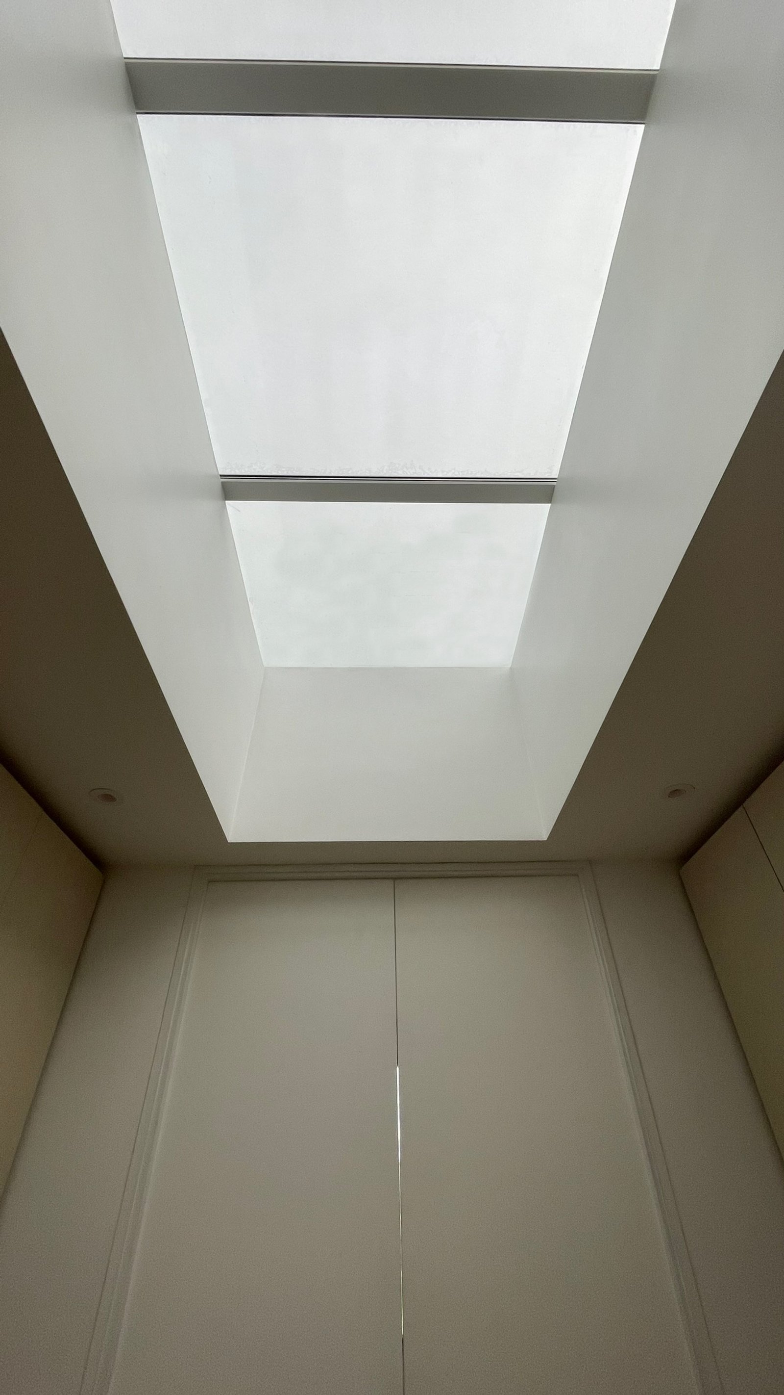 Pasillo minimalista con claraboya doble y armarios empotrados — proyecto Casa ER , por Hermann Arquitectos, en Arribeños 1611
