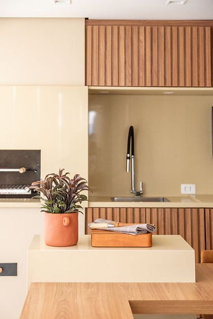 Cocina moderna con isla beige, mesada de madera y detalles en terracota — proyecto Apartamento Vila Leopoldina VIII, por Bordin E Soares Interiores