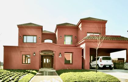 Casa moderna color terracota con techo a dos aguas y garaje — proyecto San Marcos 2, por Marconi Silva Arquitectos, en Benavidez