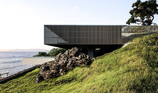 Casa moderna suspendida sobre rocas junto al mar con vista panorámica — proyecto Casa Ponte, por Tetro Arquitetura