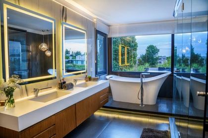 Baño moderno con bañera exenta y vista panorámica — proyecto trv 427, por Estudio Arq Daniel Tarrio