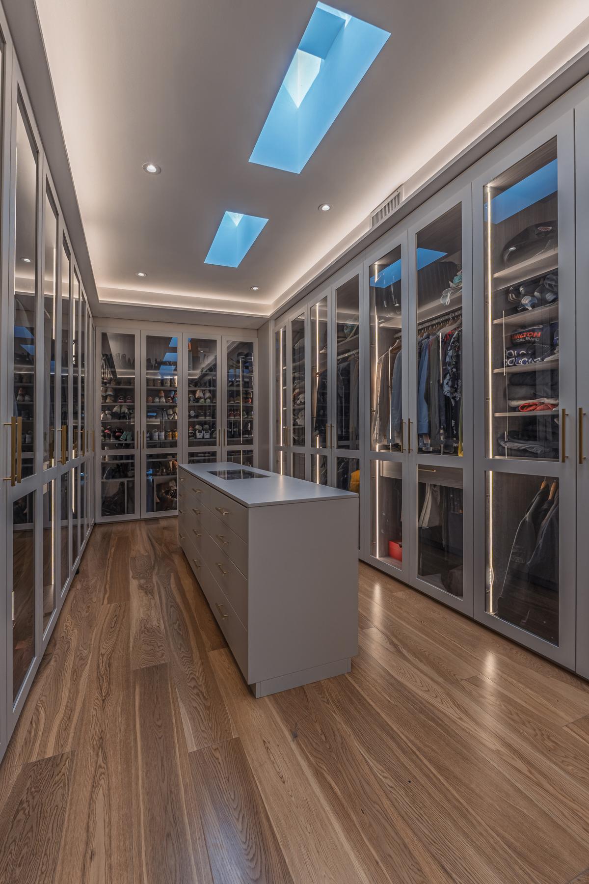 Closet moderno com ilha central e claraboias — projeto Greenville, por ABEJA CONCEPT, em C. 152