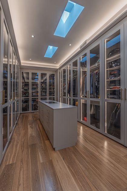 Impecable vestidor moderno con isla central y tragaluces — proyecto Greenville , por ABEJA CONCEPT, en C. 152