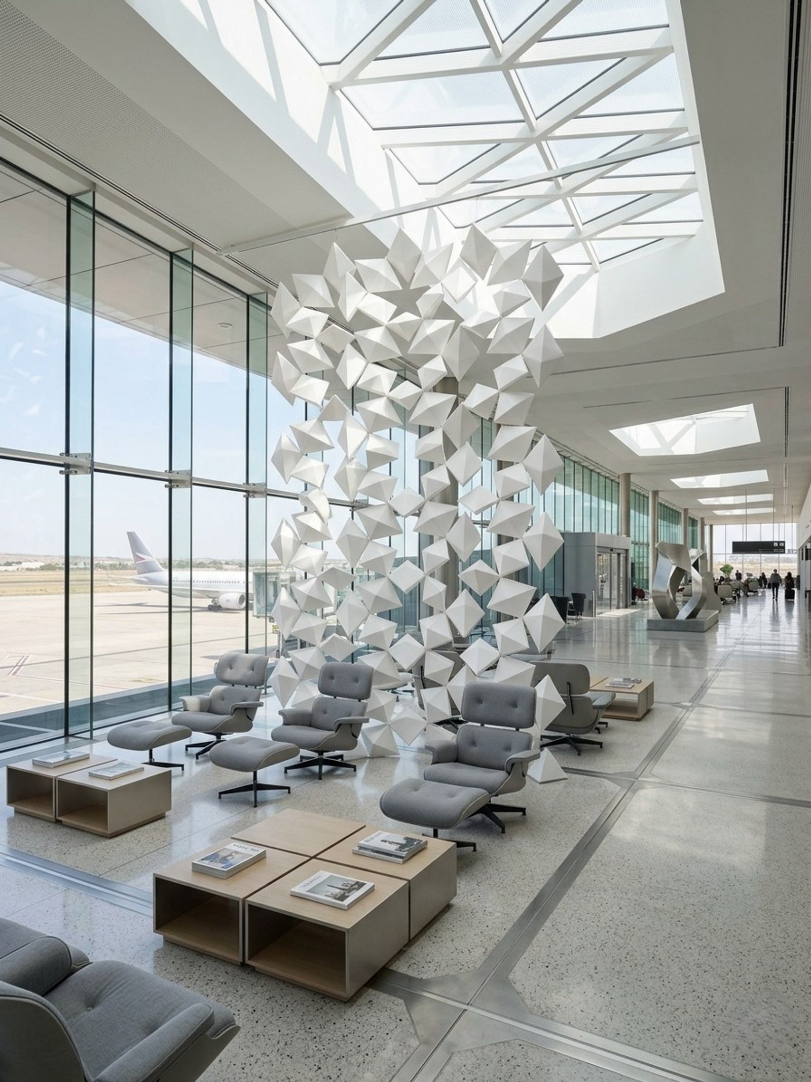 Lounge moderno de aeroporto com escultura geométrica e teto de vidro — projeto divisor escritorio, por Fus-a, em B1846 Adrogué