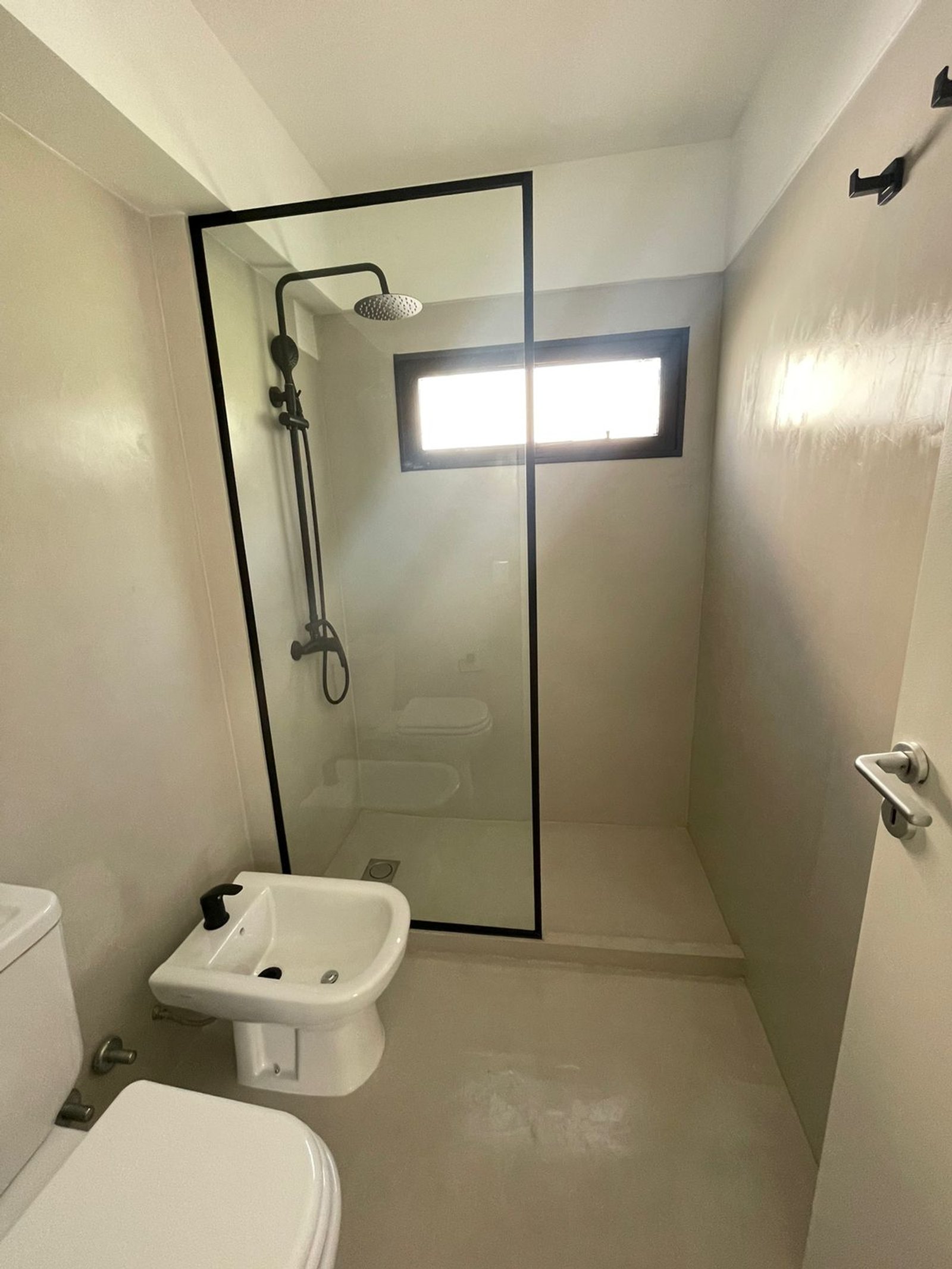 baño moderno con bidet, ducha de vidrio y ventana rectangular — proyecto Jorge Newbery , por Estudio NET Arquitectura , en Av. Jorge Newbery 1820