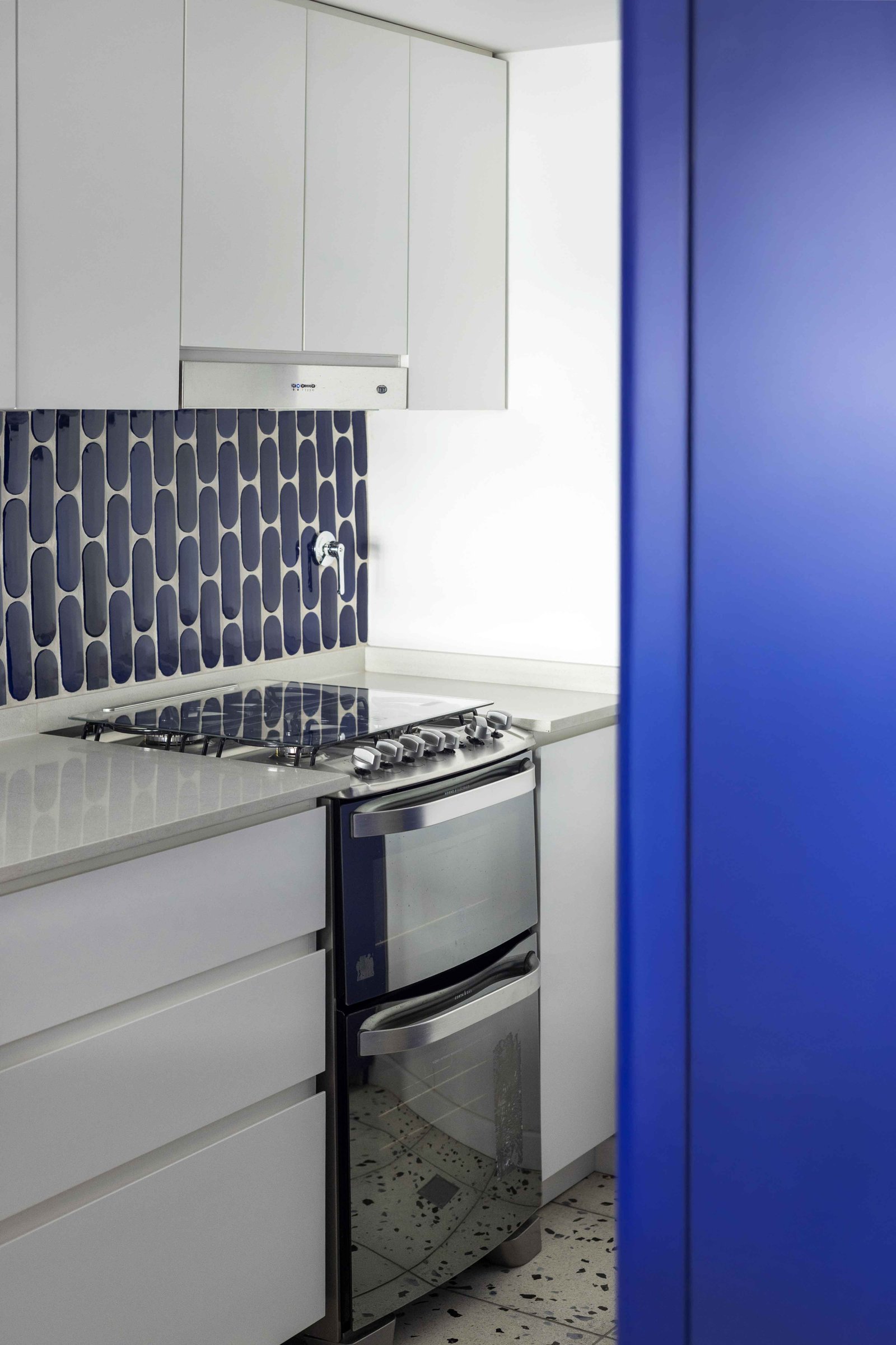 Cocina moderna con azulejos azules y muebles blancos — proyecto Julián Alvarez, por Bouré Studio, en Palermo