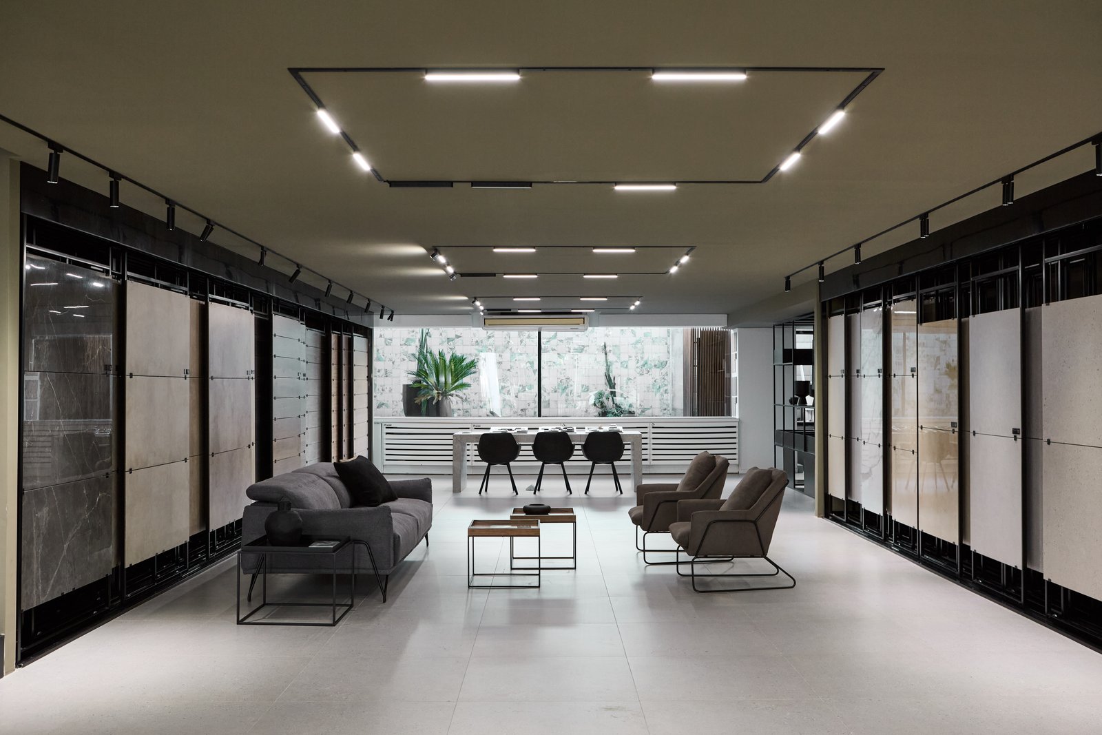 Sala de exposición de baldosas con mobiliario moderno y luz indirecta — proyecto Showroom, por San Lorenzo Design, en Buenos Aires