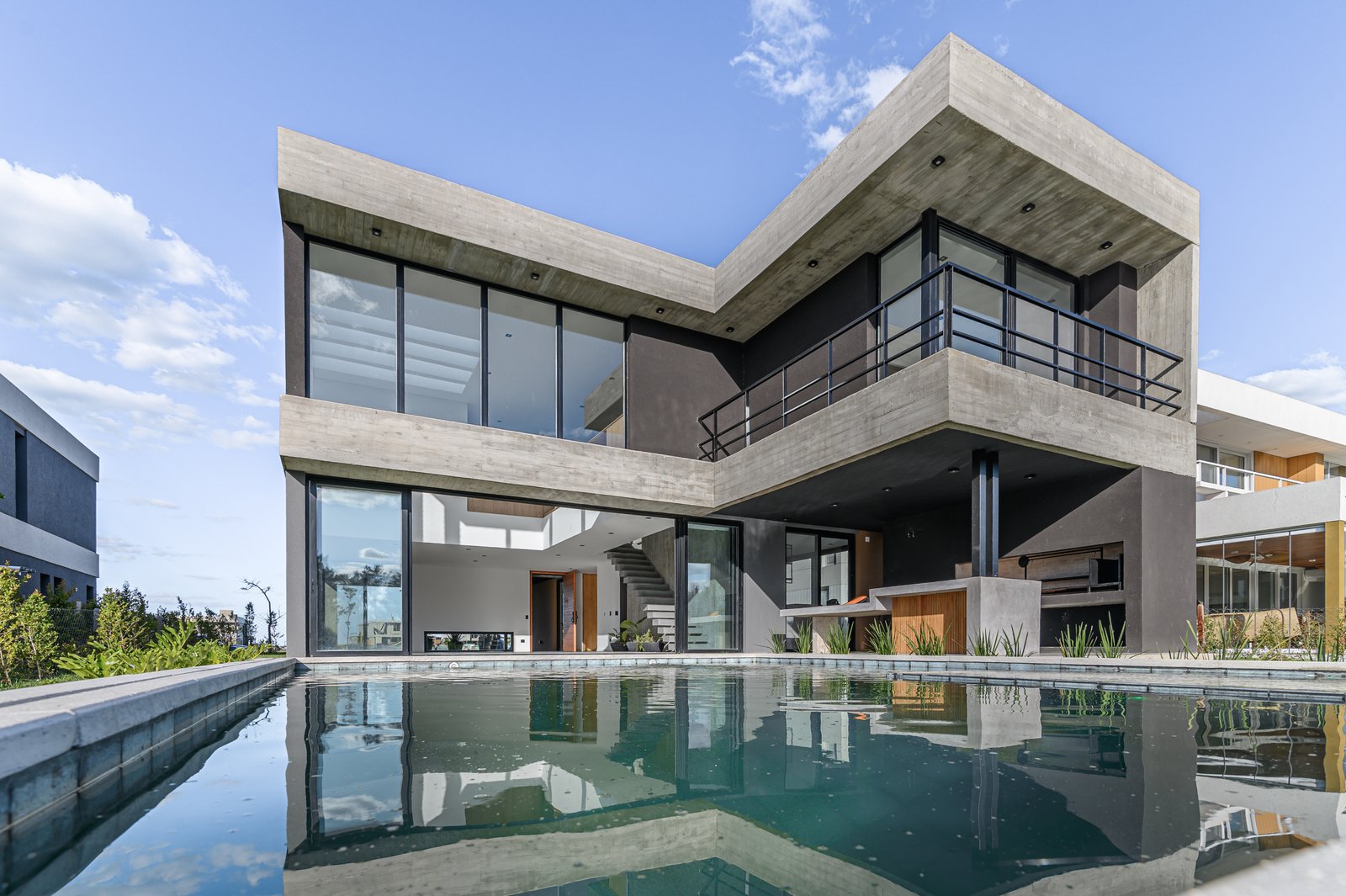 fachada moderna de concreto y vidrio con piscina — proyecto CASA CONCRETO, por Auge desarrollos & crowdfunding, en Nordelta