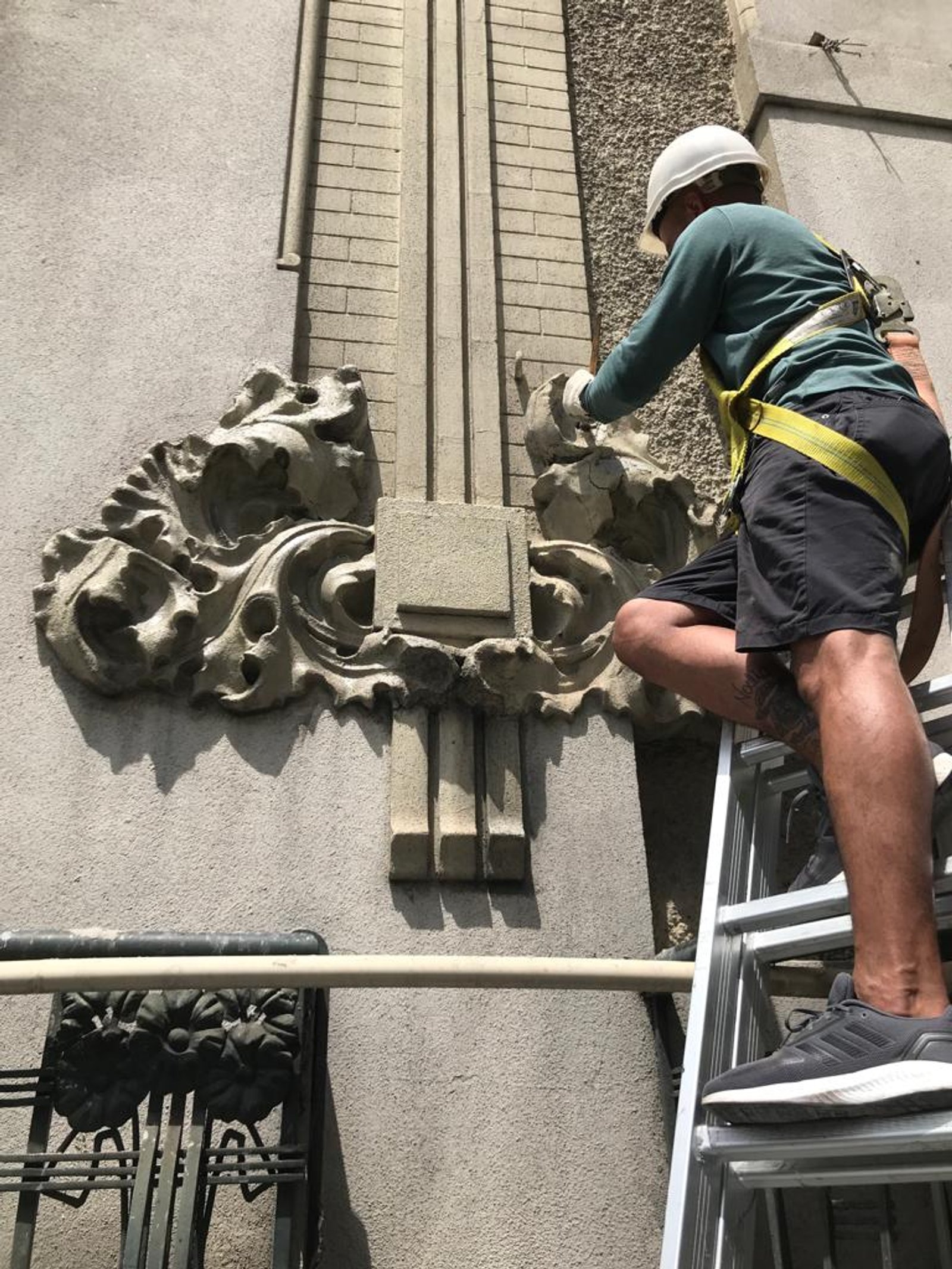 Trabajador en andamio restaurando fachada con relieves — proyecto Edificio "La Molinera", por restauracionesdefachadas8958, en Av. Sta. Fe & Pres. José Evaristo Uribur