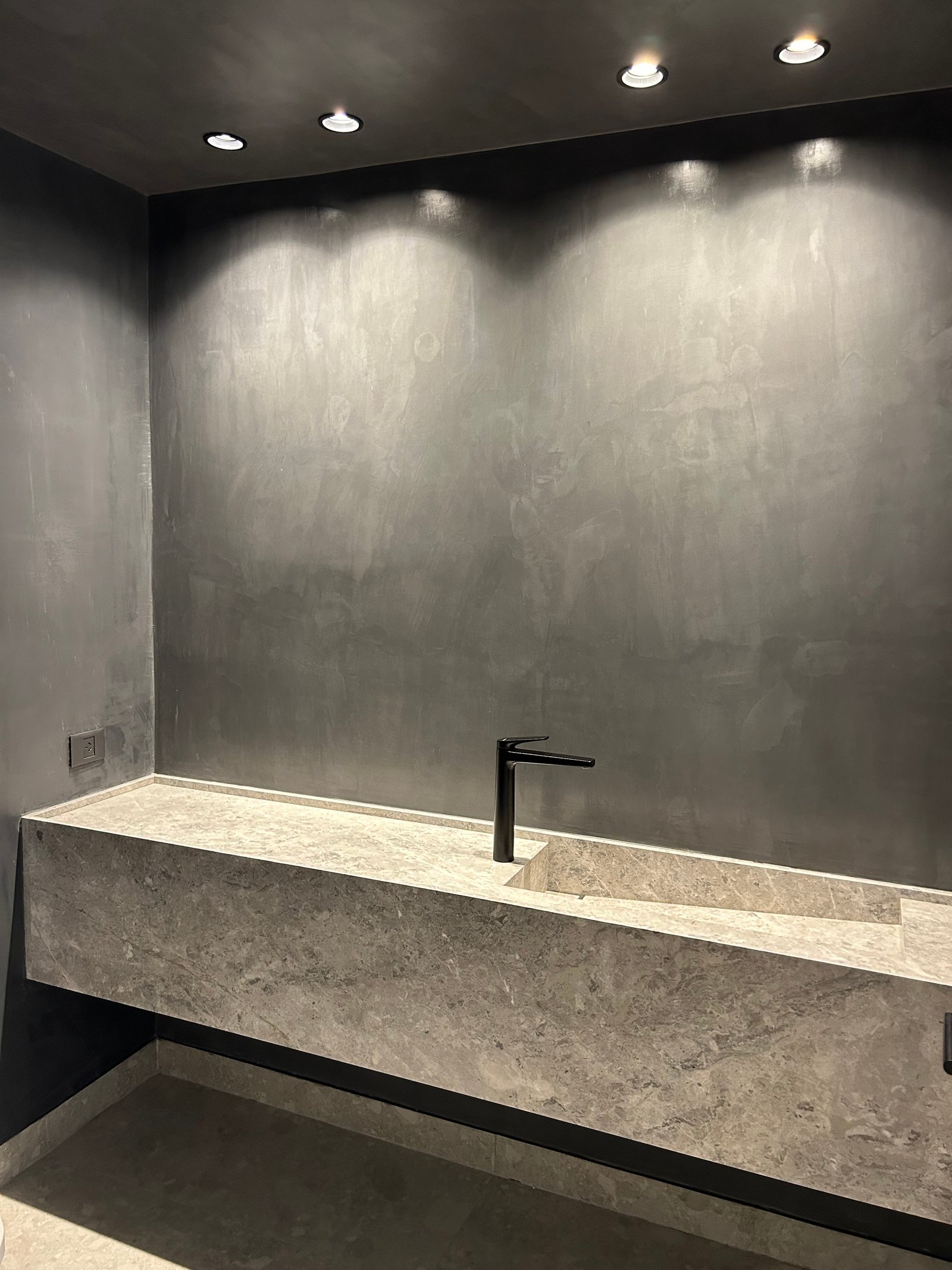 Baño moderno con mesada de mármol y pared de cemento alisado — proyecto LIBERTADOR II, por ESTUDIO TEZ, en Palermo