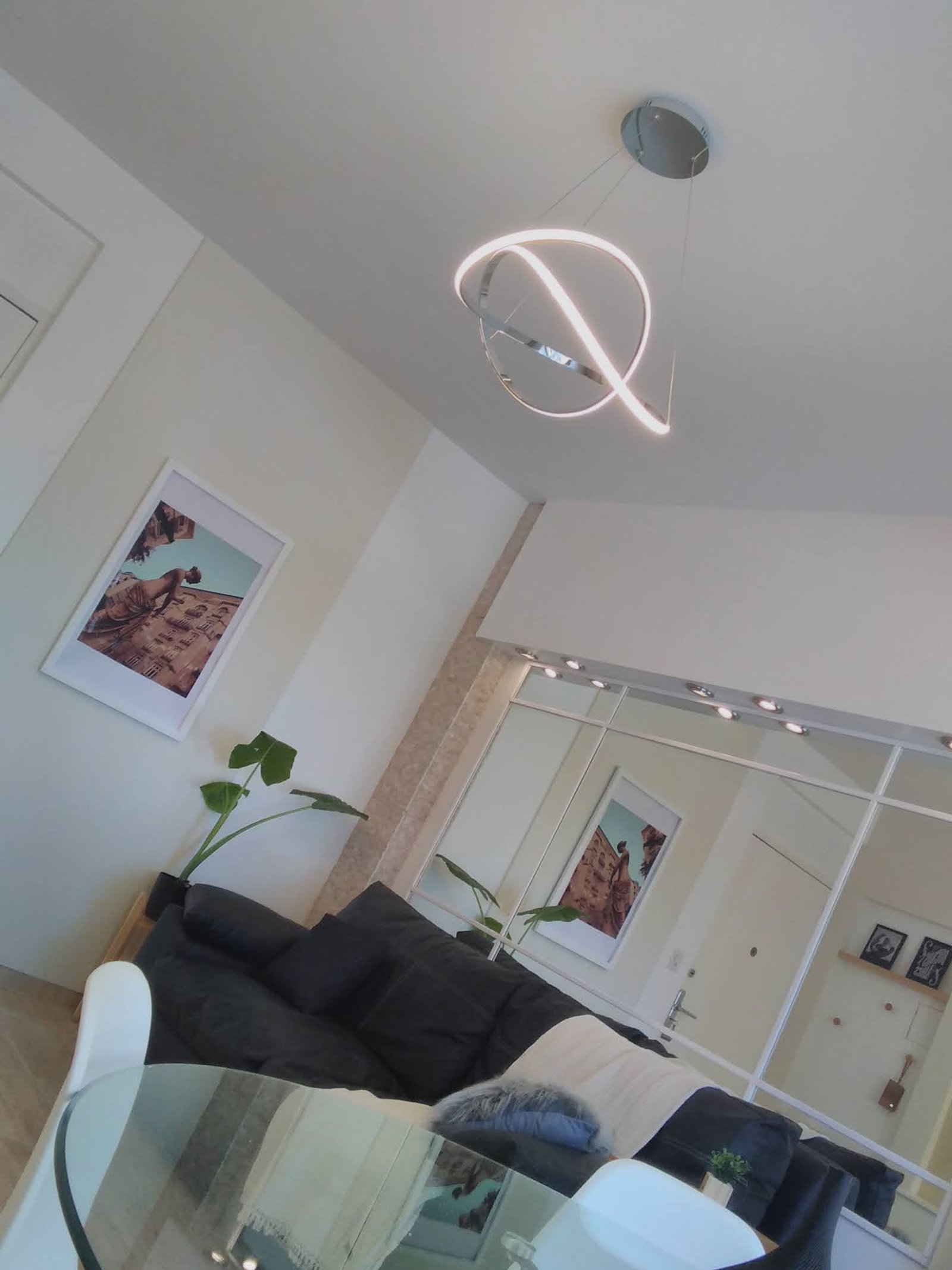 Sala de estar moderna con lámpara colgante abstracta y sofá modular — proyecto Vivienda Palermo , por HEIM ARQUITECTURA INTERIOR , en Palermo Hollywood