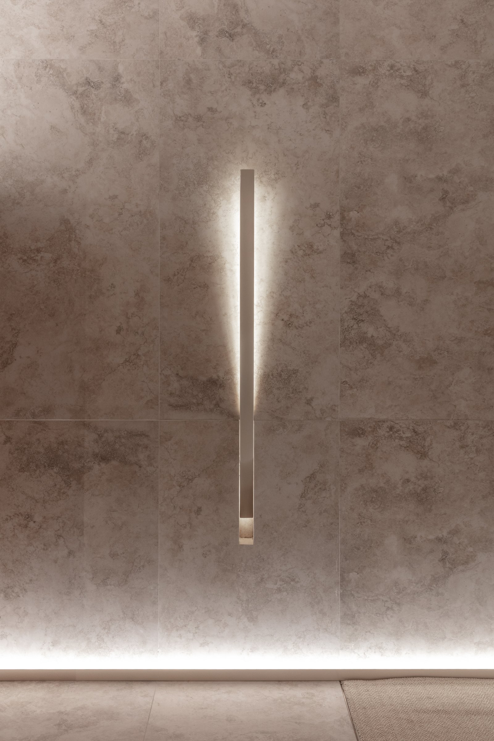 Pasillo moderno con paredes y piso de piedra texturizada y luz lineal — proyecto Casa Foa 2025 | Degustando experiencias | Tasting experiences | Lucia Quinteros, por Ren Studio, en
