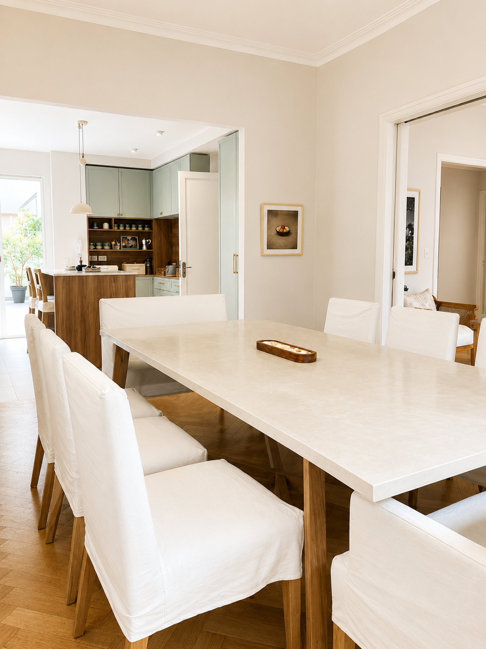Comedor moderno con cocina abierta y sillas blancas — proyecto Arenales, por Equipe, en Buenos Aires