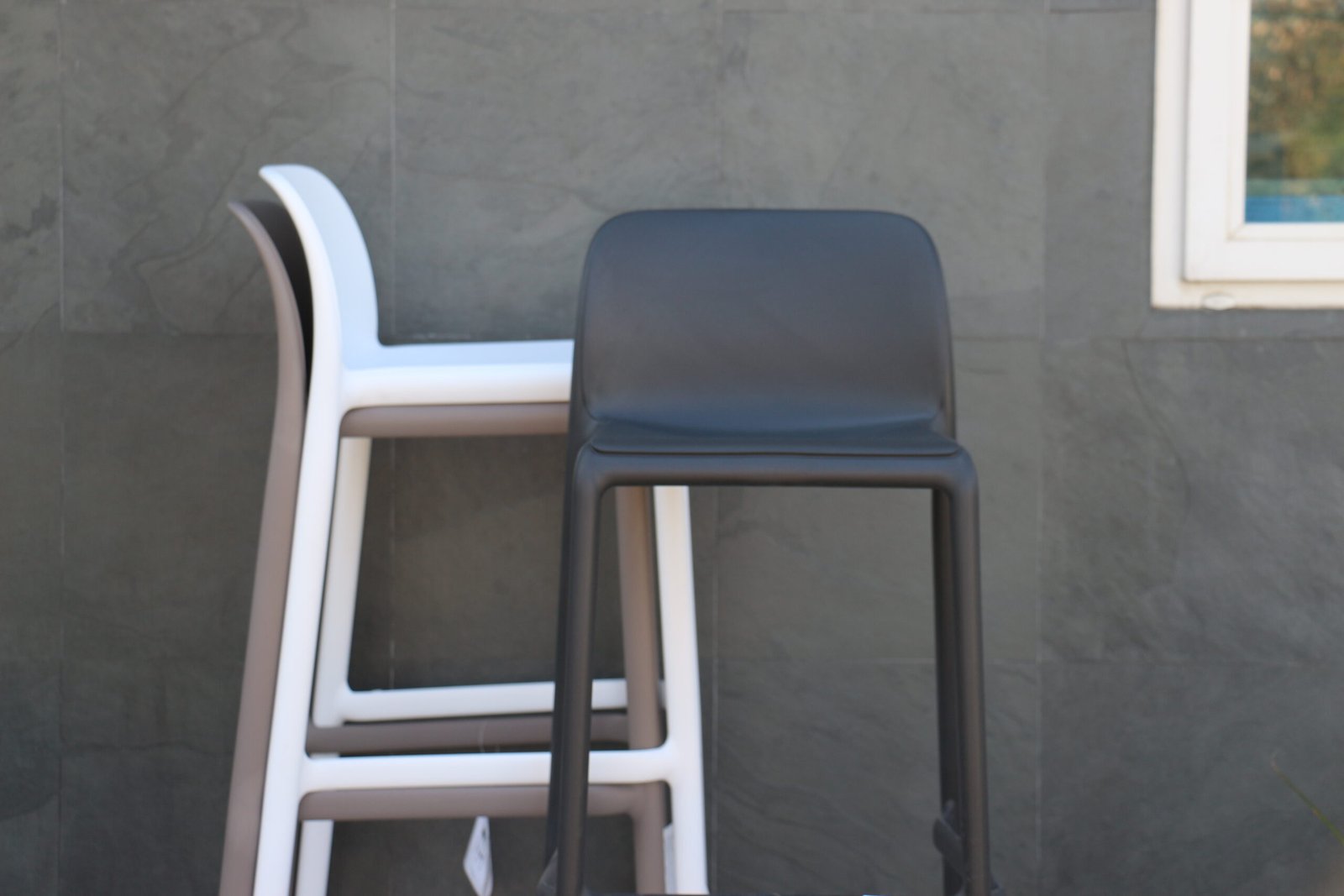 Dos banquetas altas modernas de plástico negro y blanco, al aire libre — proyecto Barras, por Casa Nuñez
