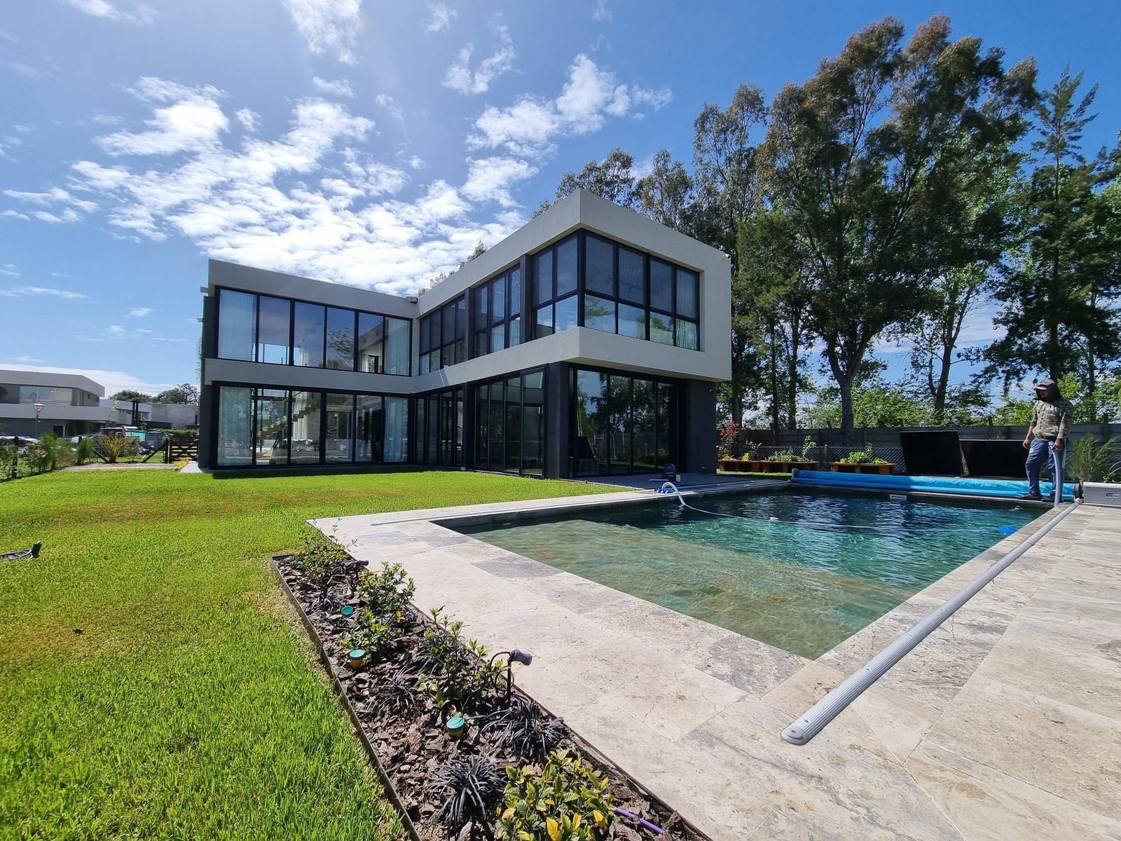 Fachada moderna branca com piscina e vegetação — projeto CASA T199, por A'PRIMA - Arquitectura Sustentable, em Los Robles 5901
