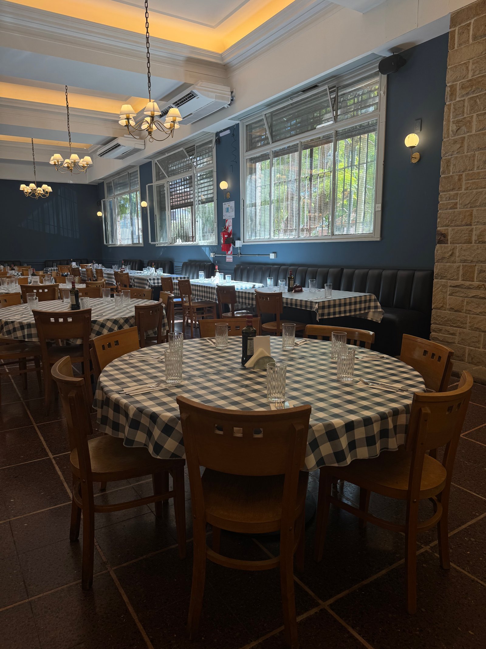 comedor de restaurante con mesas a cuadros y sillas de madera — proyecto Galicia restaurante , por Remodela tu local , en Retiro